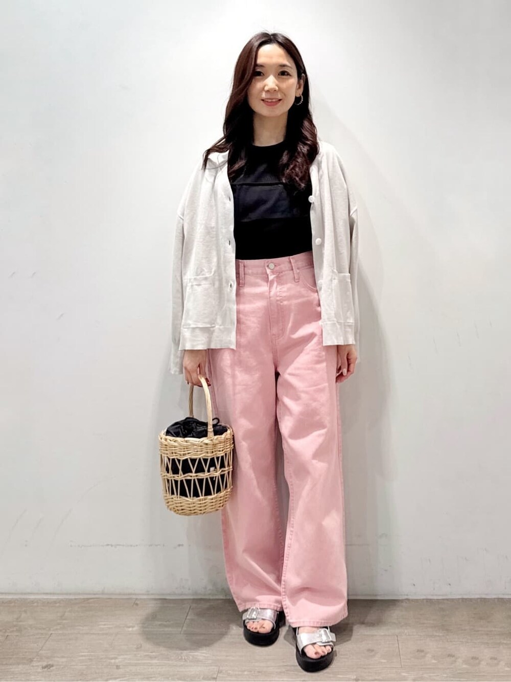 グレー系のカーディガン/ボレロ、ブラック系のTシャツ/カットソー、ピンク系のデニムパンツを着用したレディースの春コーディネートの2枚目の写真