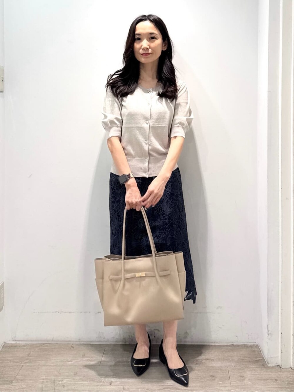 ベージュ系のカーディガン/ボレロ、ブルー系のスカート、ベージュ系のトートバッグを着用したレディースの秋コーディネートの3枚目の写真