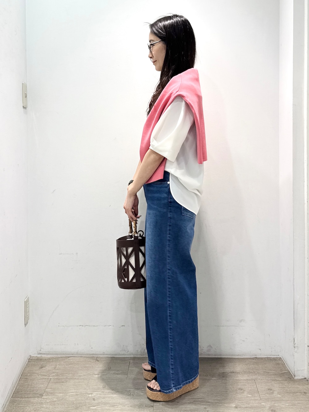 ブルー系のデニムパンツ、ホワイト系のシャツ/ブラウス、ブラウン系のハンドバッグを着用したレディースの春コーディネートの8枚目の写真