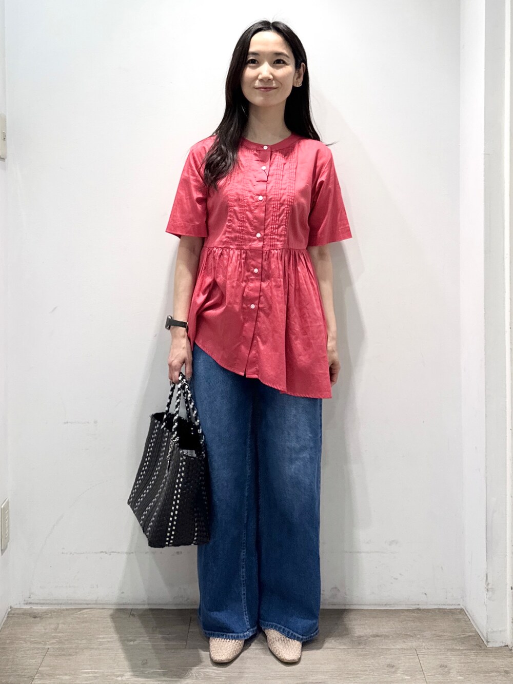 ブルー系のデニムパンツ、ブラック系のトートバッグ、ベージュ系のパンプスを着用したレディースの春コーディネートの4枚目の写真