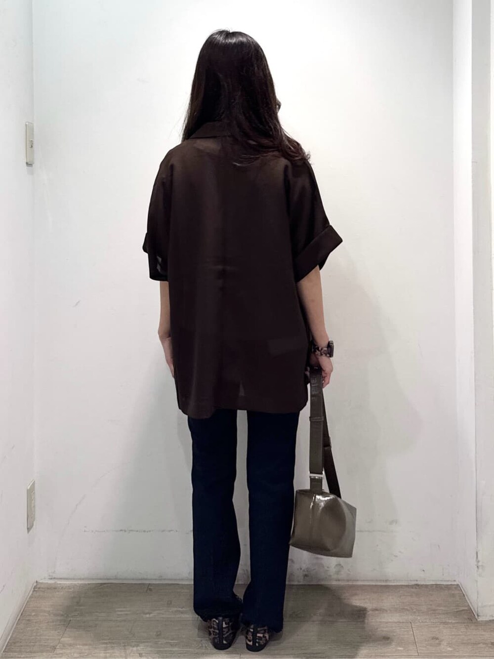 ブラウン系のテーラードジャケット、ベージュ系のTシャツ/カットソー、ブルー系のデニムパンツを着用したレディースの秋コーディネートの6枚目の写真