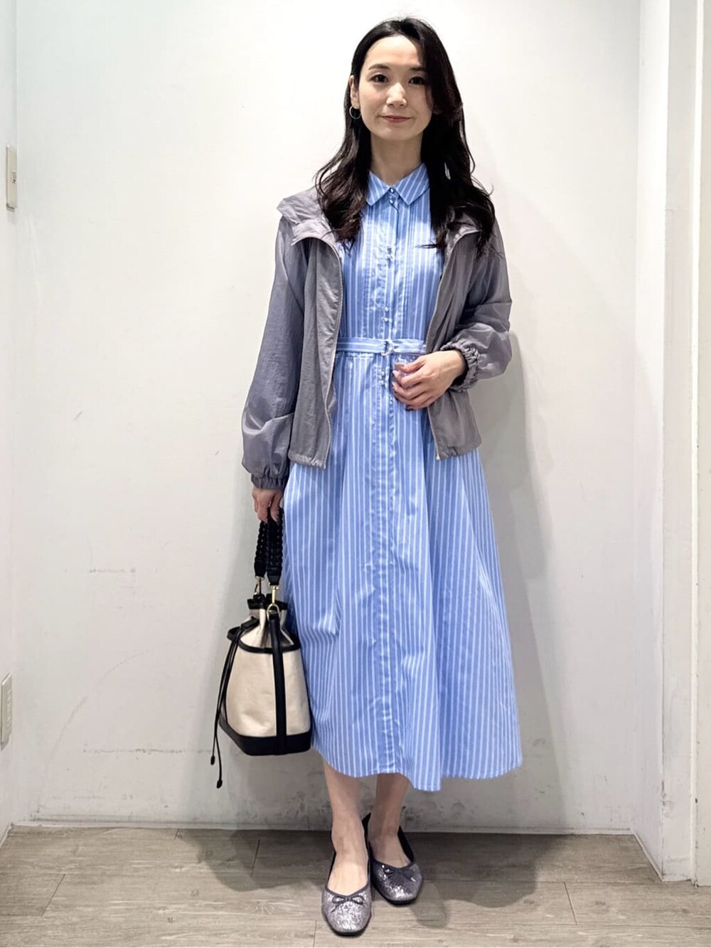 シルバー系のパンプス、ブルー系のワンピース、グレー系のブルゾンを着用したレディースの春コーディネートの2枚目の写真