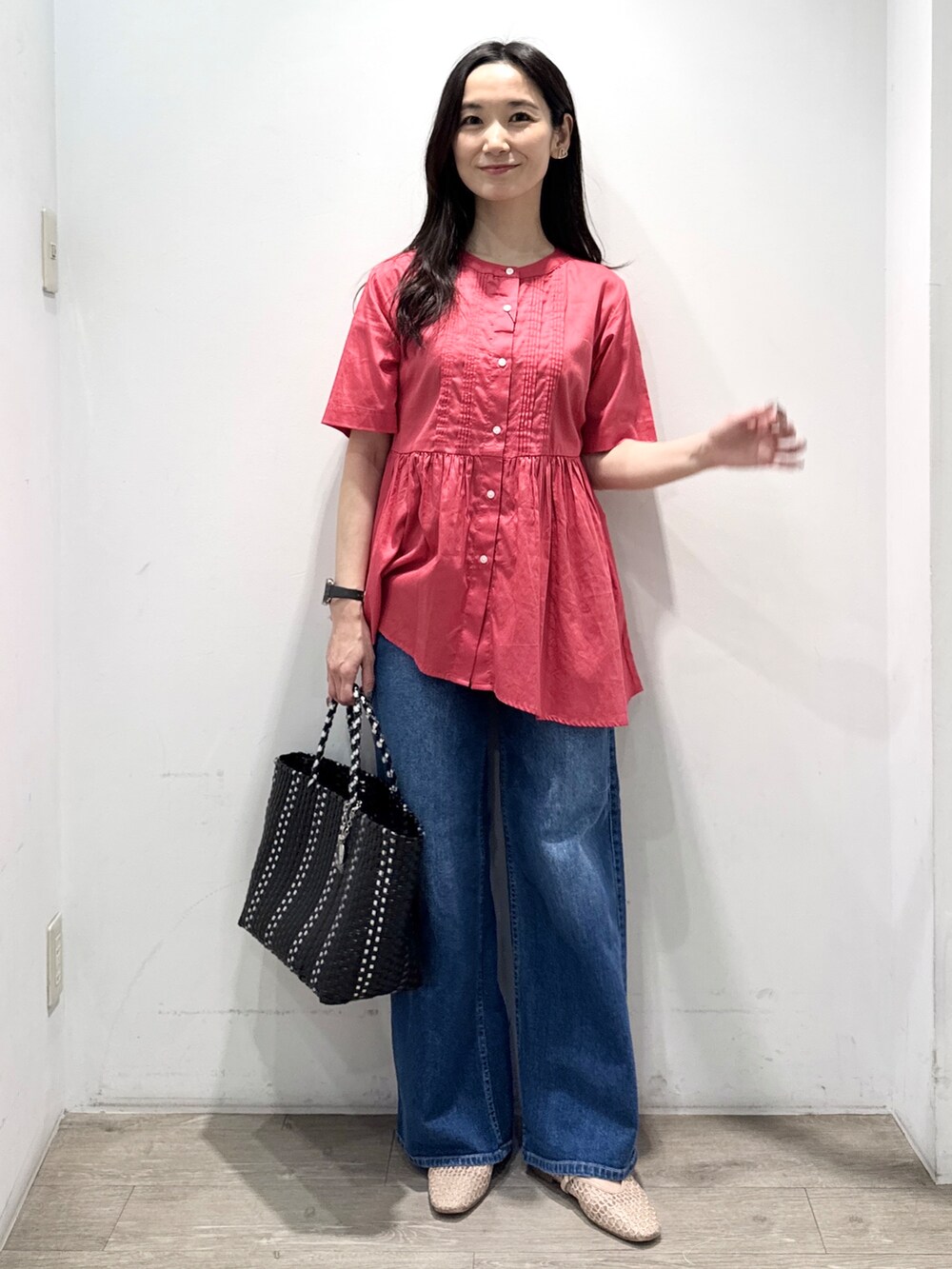 ブルー系のデニムパンツ、ブラック系のトートバッグ、ベージュ系のパンプスを着用したレディースの春コーディネートの5枚目の写真