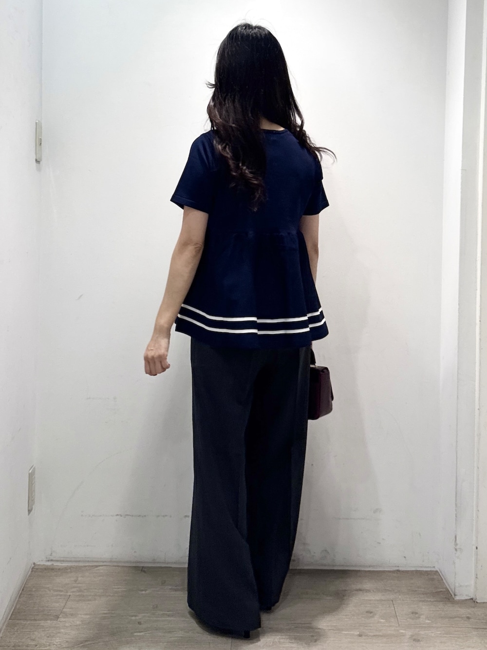 ブルー系のニット/セーター、グレー系のその他パンツ、レッド系のショルダーバッグを着用したレディースの夏コーディネートの8枚目の写真