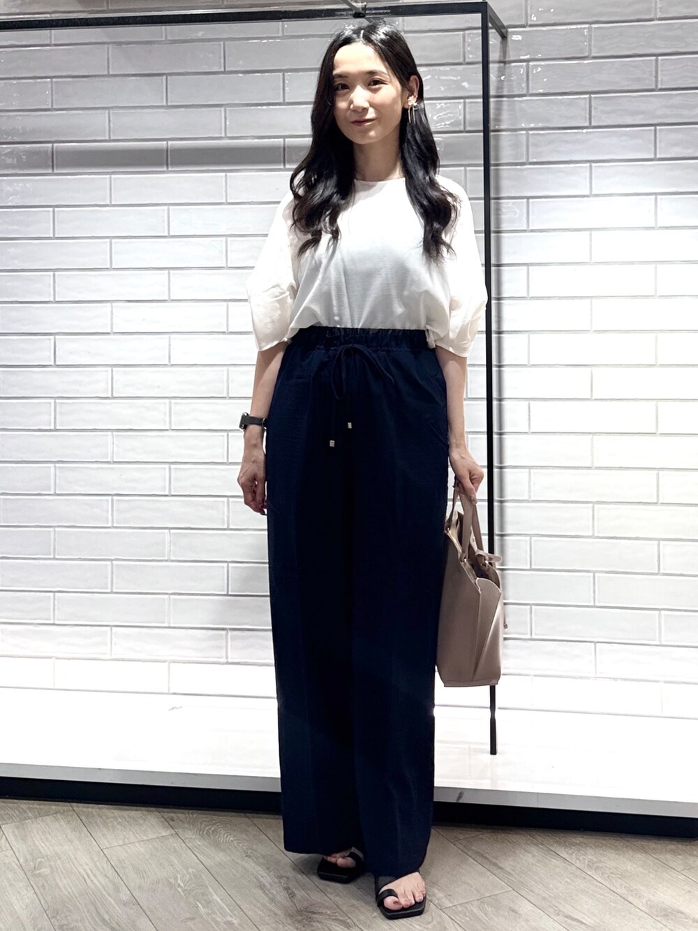 ホワイト系のシャツ/ブラウス、ブルー系のその他パンツ、ベージュ系のトートバッグを着用したレディースの夏コーディネートの2枚目の写真