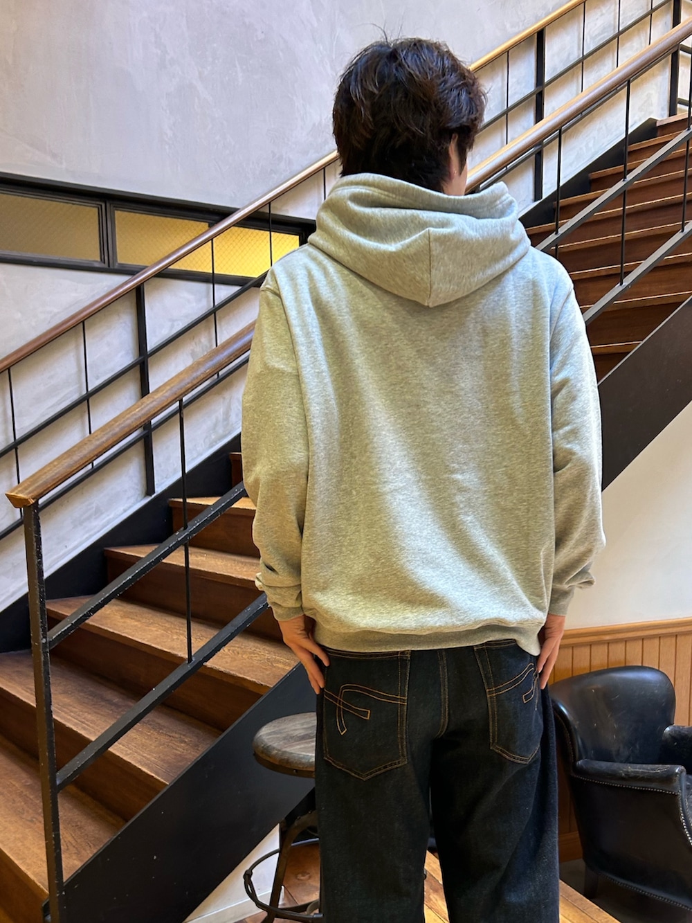 グレー系のパーカー、グレー系のデニムパンツを着用したメンズの秋コーディネートの2枚目の写真