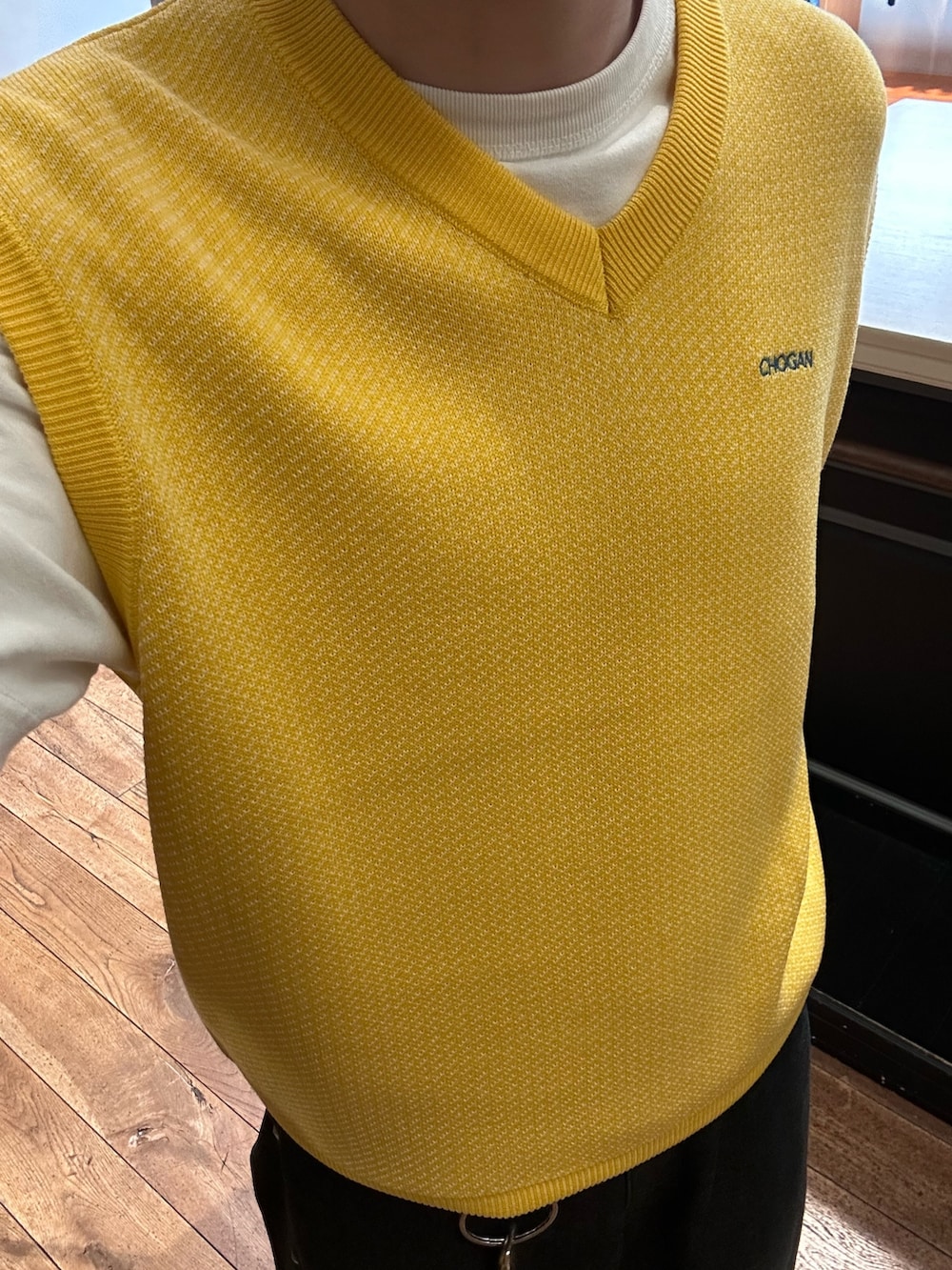 イエロー系のニット/セーター、ブラック系のデニムパンツを着用したメンズの春コーディネートの3枚目の写真