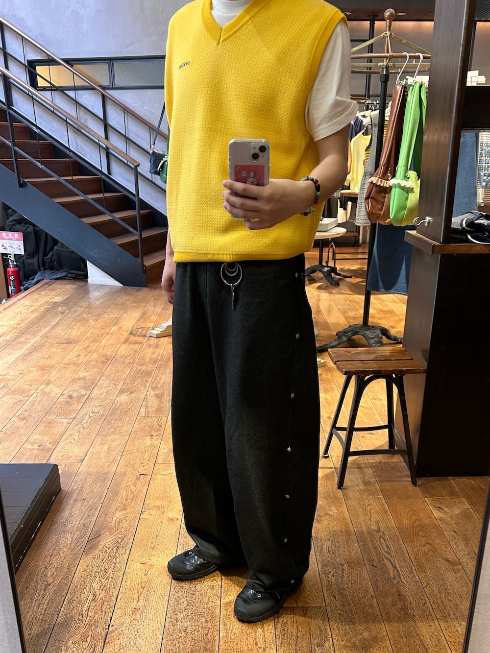 イエロー系のニット/セーター、ブラック系のデニムパンツを着用したメンズの春コーディネートの2枚目の写真