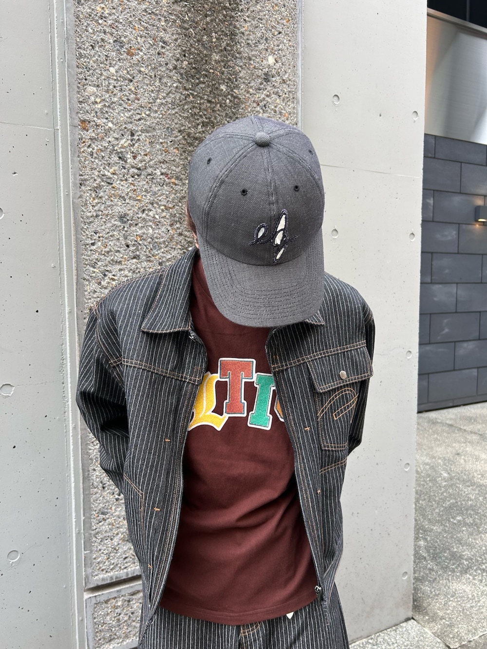 グレー系のデニムパンツ、グレー系のデニムジャケット、ブラウン系のTシャツ/カットソーを着用したメンズの秋コーディネートの3枚目の写真
