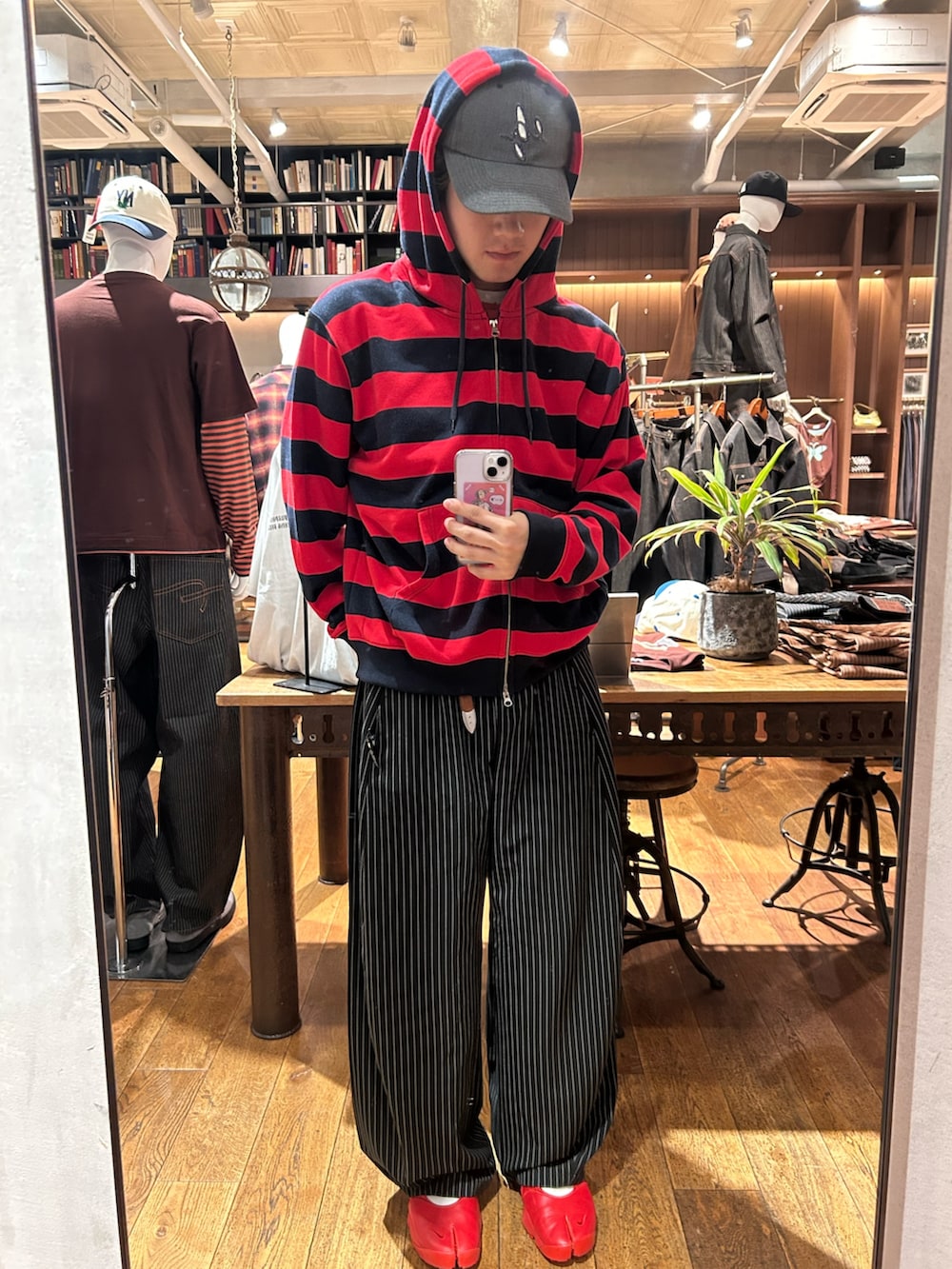 レッド系のTシャツ/カットソー、ブラック系のスラックスを着用したメンズの夏コーディネートの2枚目の写真