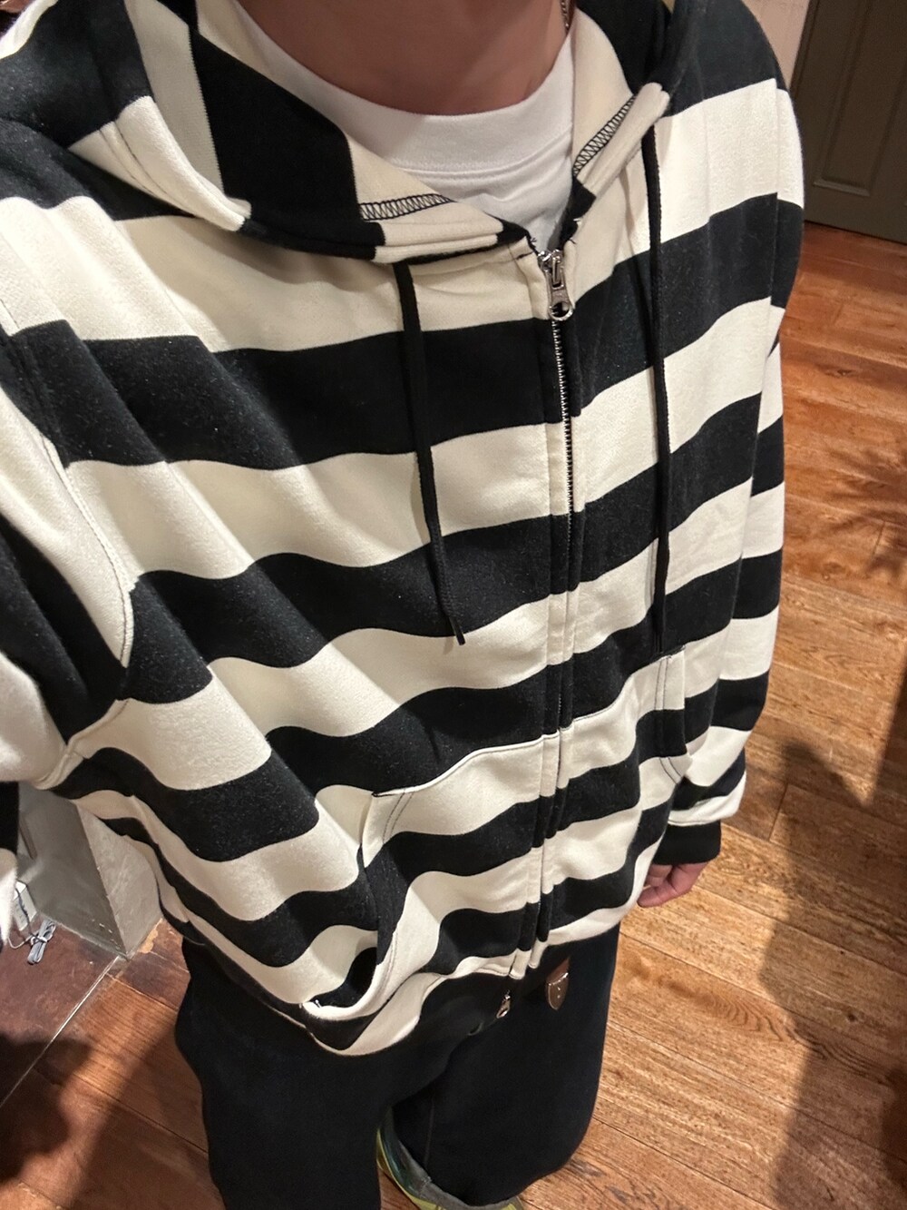 ホワイト系のTシャツ/カットソー、ブルー系のデニムパンツを着用したメンズの秋コーディネートの3枚目の写真