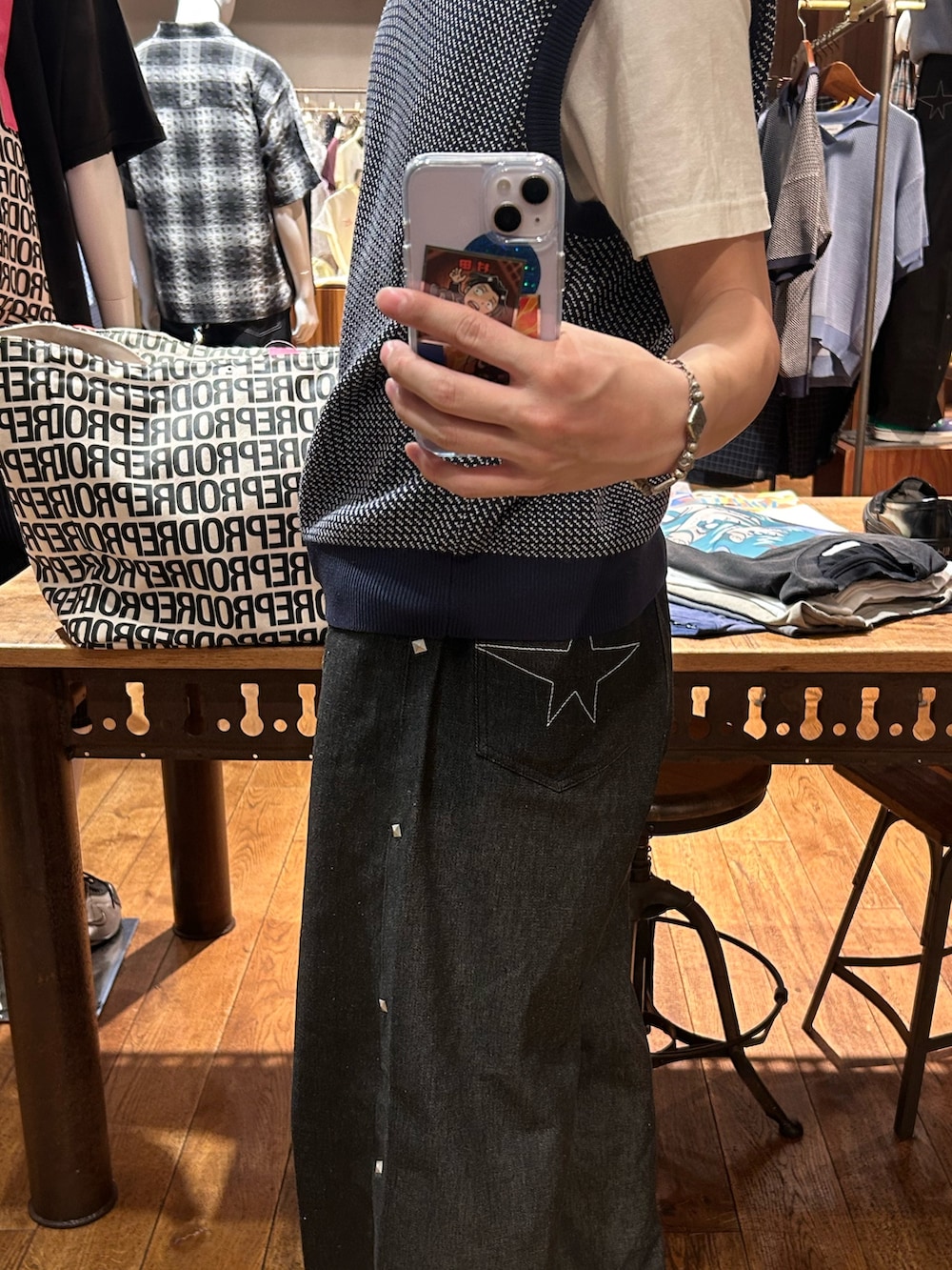 ブルー系のニット/セーター、ブラック系のデニムパンツを着用したメンズの春コーディネートの3枚目の写真