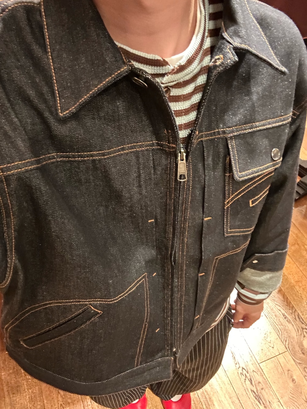 ブルー系のデニムジャケット、グリーン系のTシャツ/カットソー、ブラック系のスラックスを着用したメンズの夏コーディネートの3枚目の写真