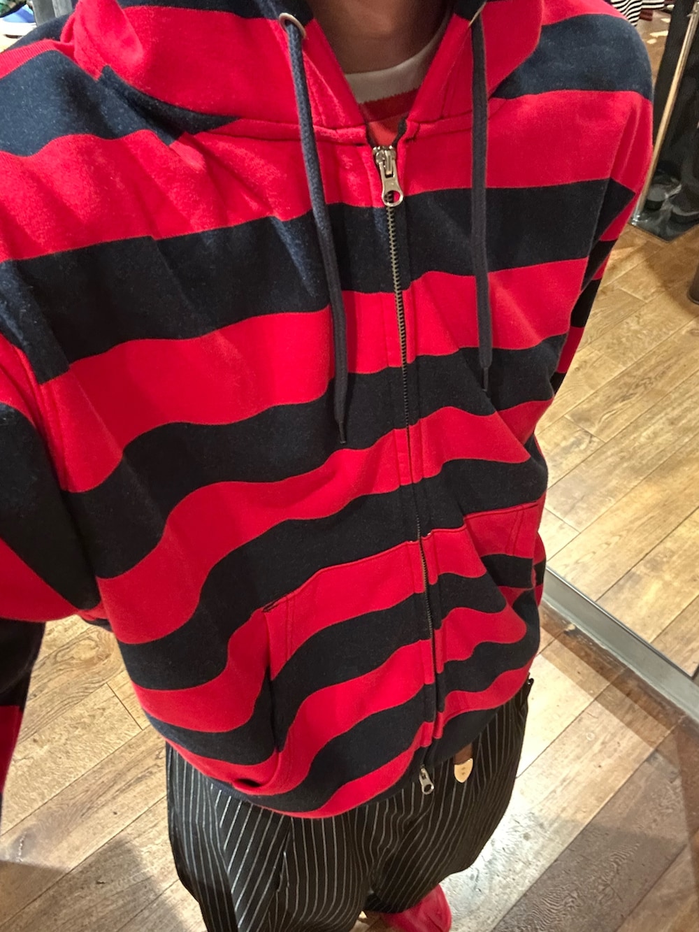 レッド系のTシャツ/カットソー、ブラック系のスラックスを着用したメンズの夏コーディネートの3枚目の写真
