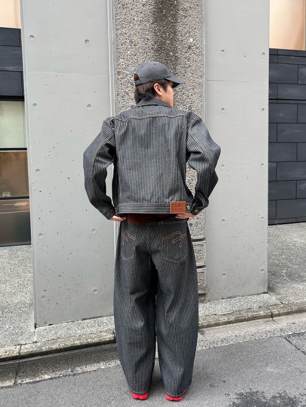 グレー系のデニムパンツ、グレー系のデニムジャケット、ブラウン系のTシャツ/カットソーを着用したメンズの秋コーディネートの2枚目の写真
