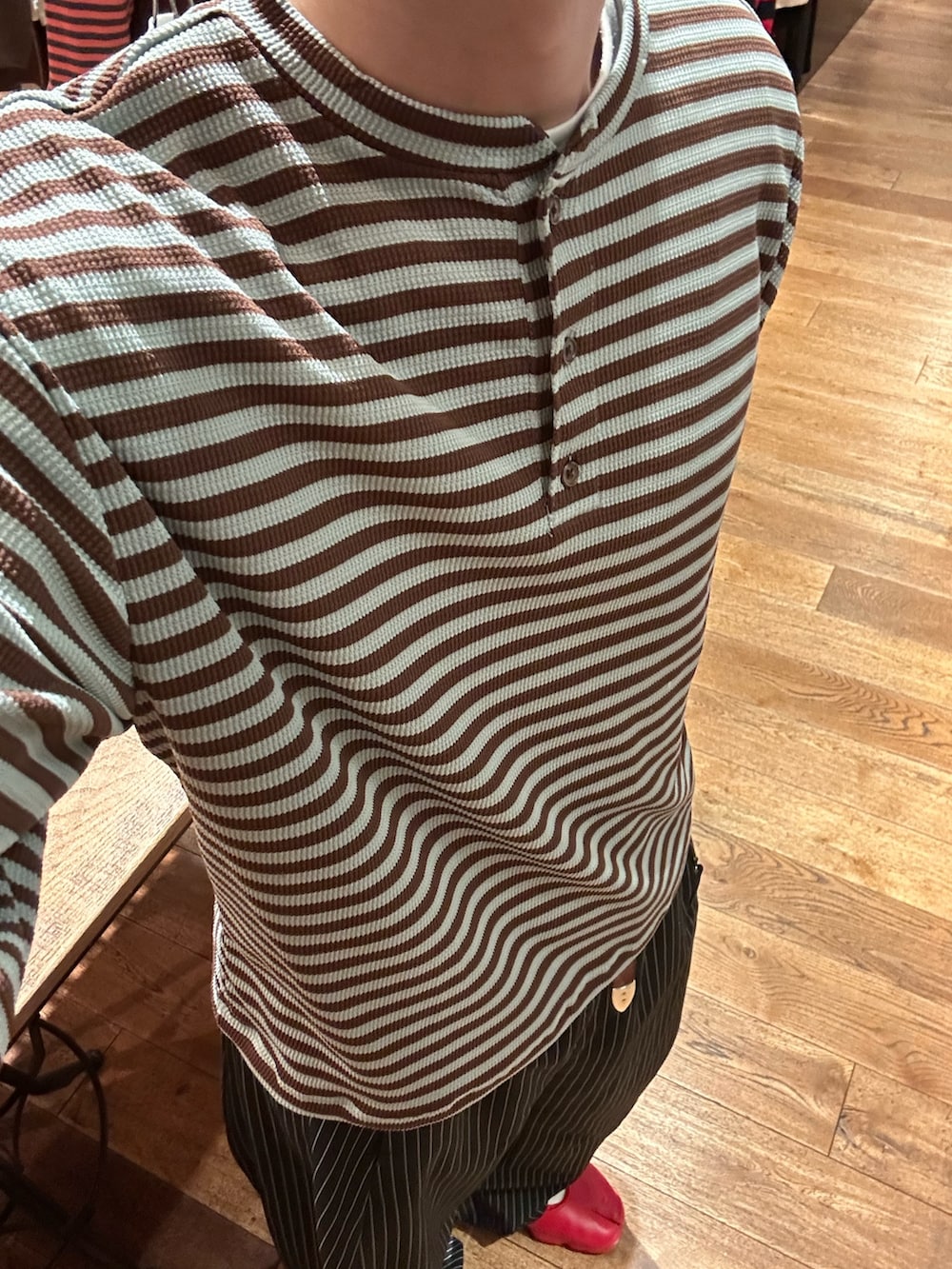 グリーン系のTシャツ/カットソー、ブラック系のスラックスを着用したメンズの夏コーディネートの3枚目の写真