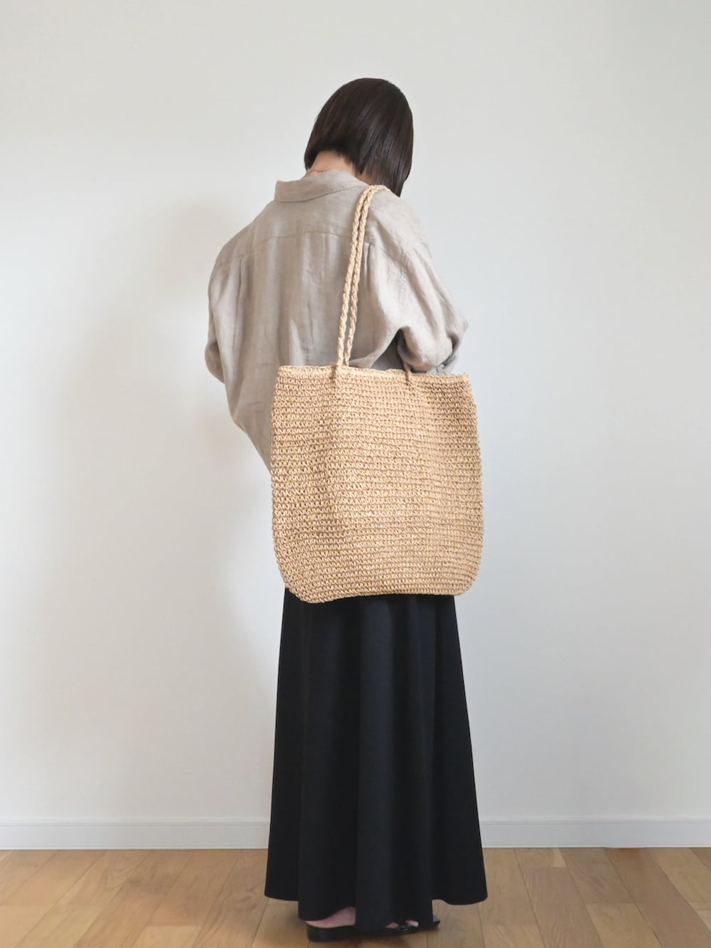 ブラック系のスカート、ブラウン系のシャツ/ブラウス、その他のかごバッグを着用したレディースの夏コーディネートの2枚目の写真