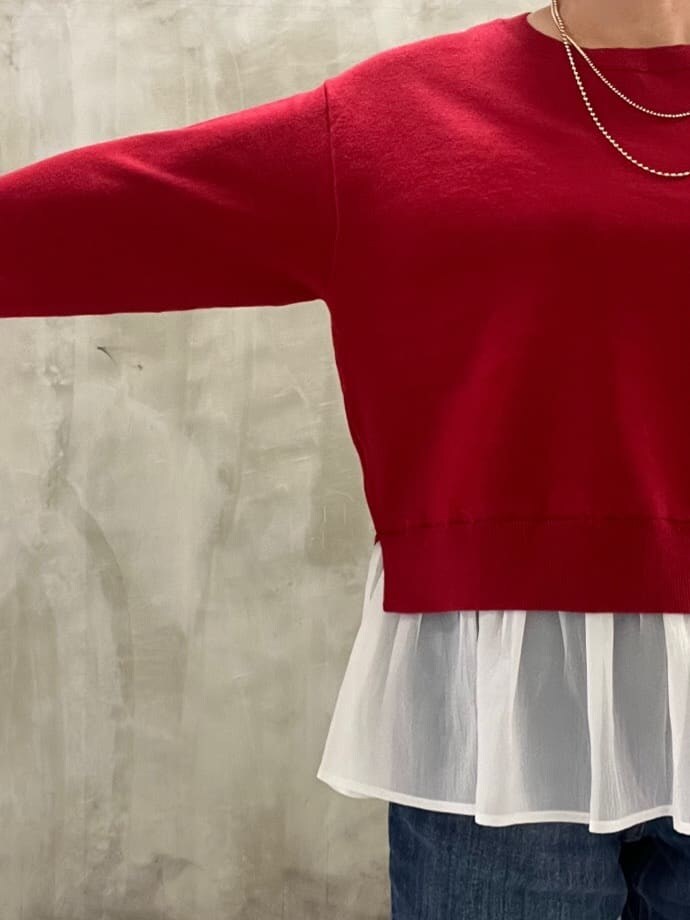 レッド系のニット/セーター、ブルー系のデニムパンツ、ブラック系のショルダーバッグを着用したレディースの秋コーディネートの4枚目の写真