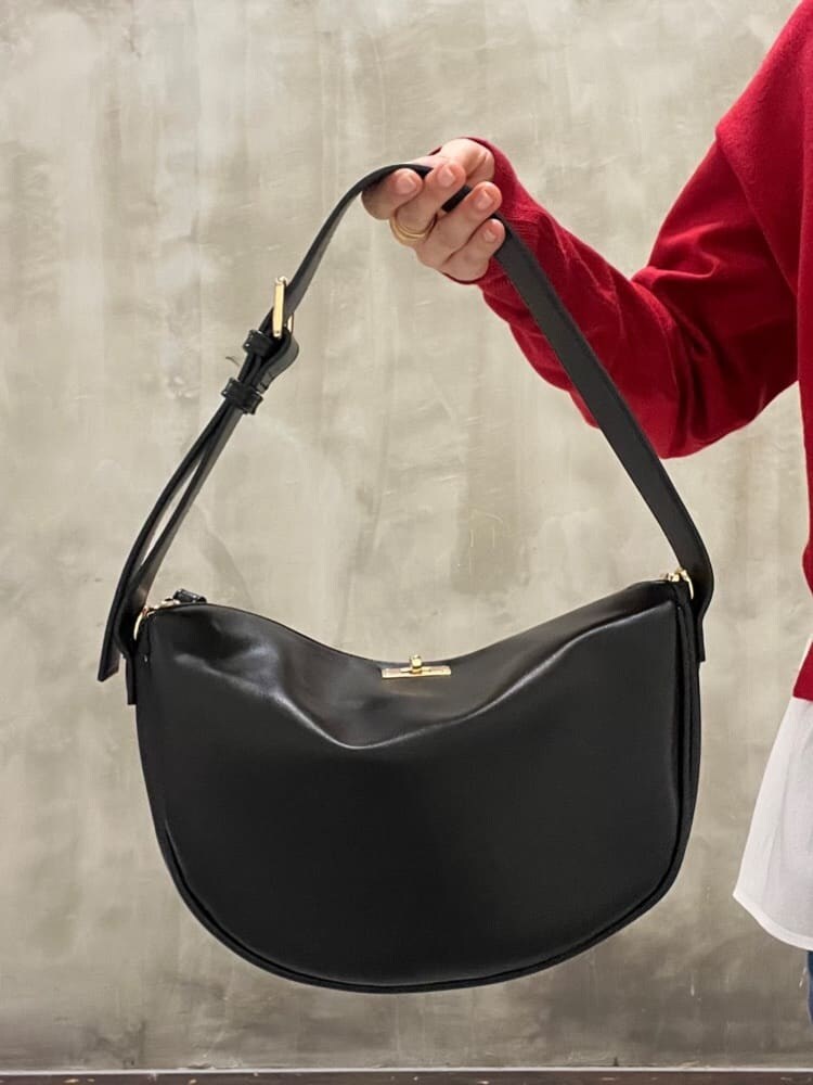 レッド系のニット/セーター、ブルー系のデニムパンツ、ブラック系のショルダーバッグを着用したレディースの秋コーディネートの5枚目の写真