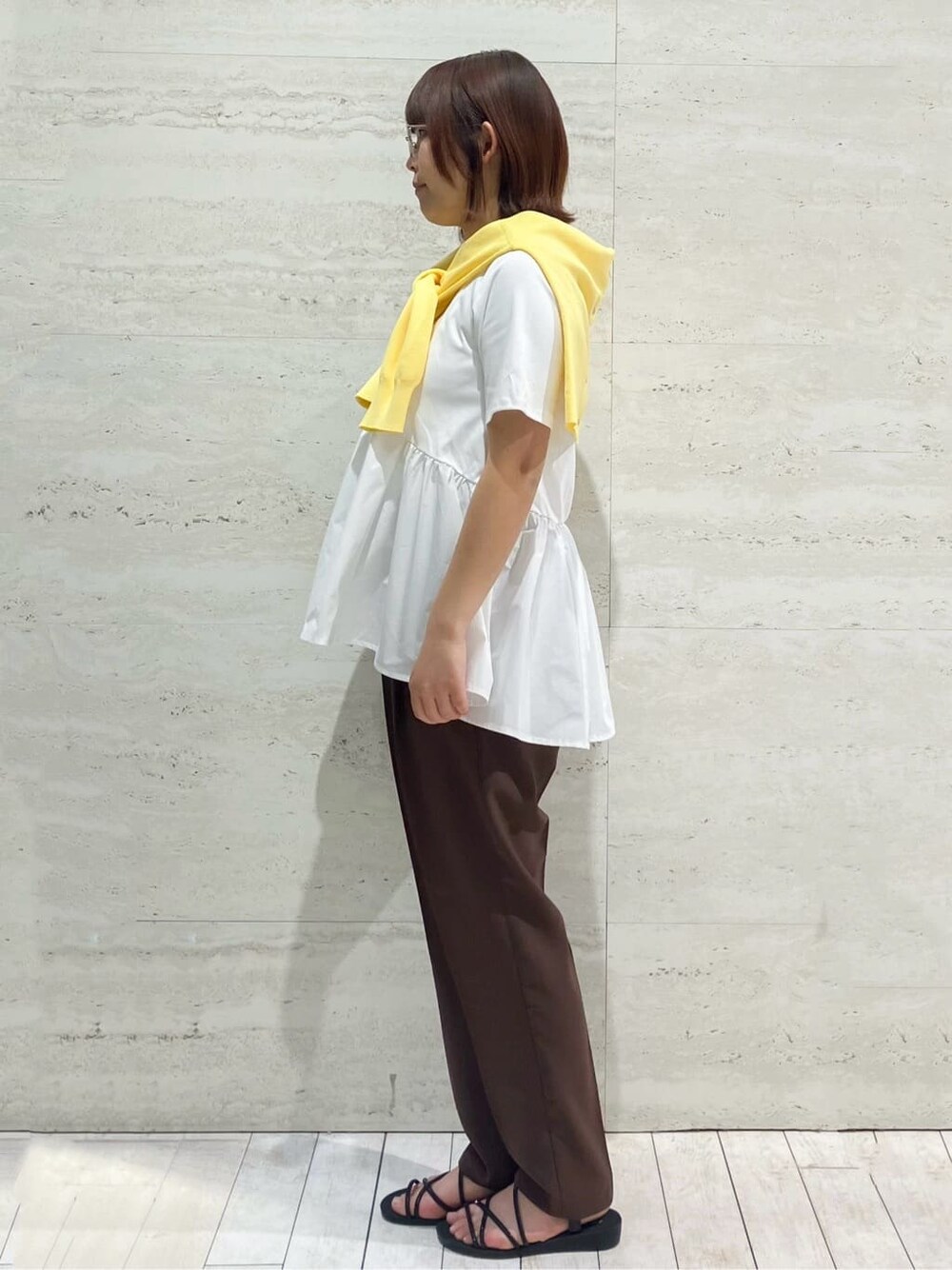 ホワイト系のTシャツ/カットソー、イエロー系のカーディガン/ボレロ、ブラウン系のその他パンツを着用したレディースの春コーディネートの2枚目の写真