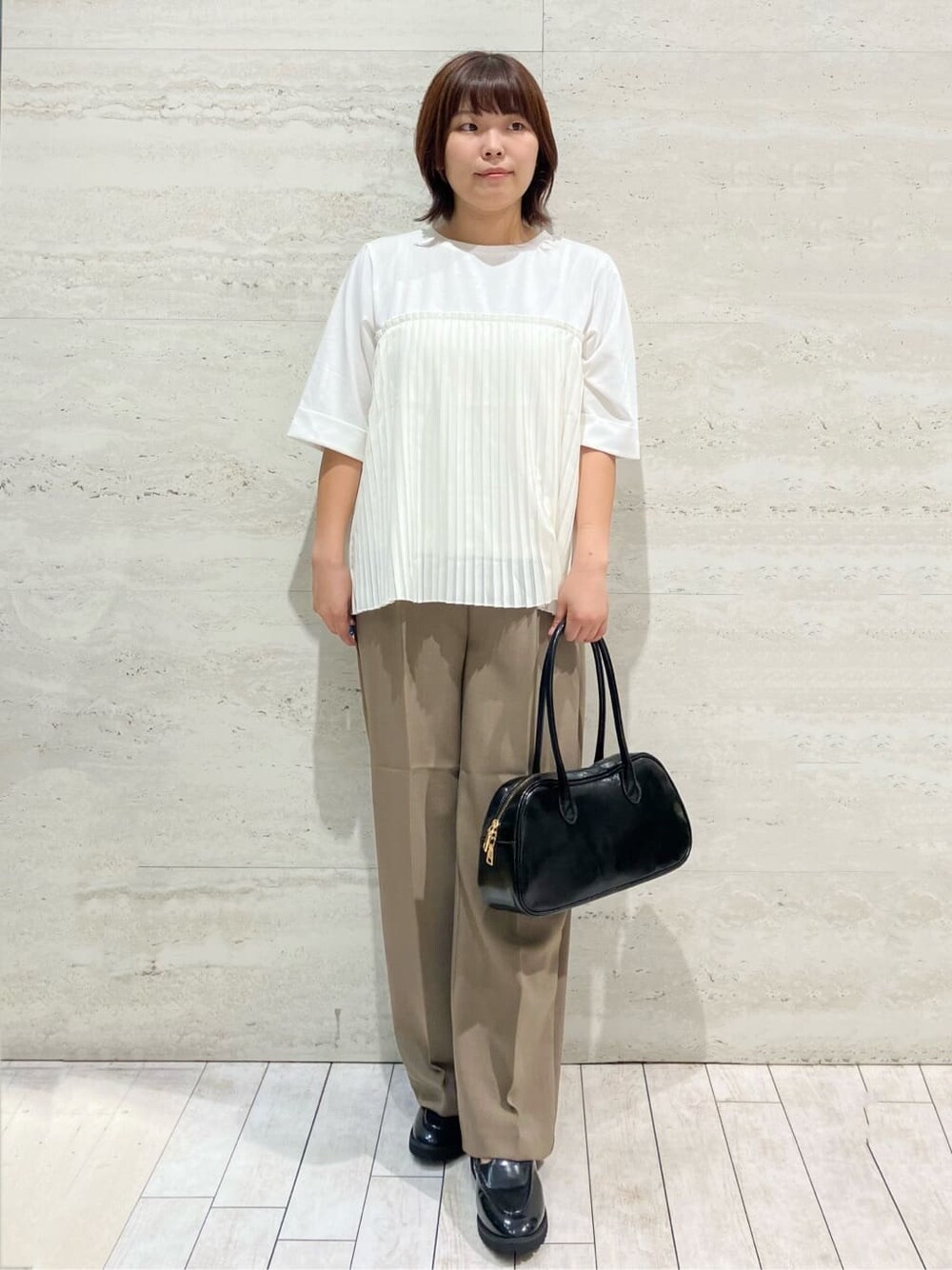 ホワイト系のTシャツ/カットソー、ブラウン系のその他パンツ、ブラック系のボストンバッグを着用したレディースの秋コーディネートの2枚目の写真