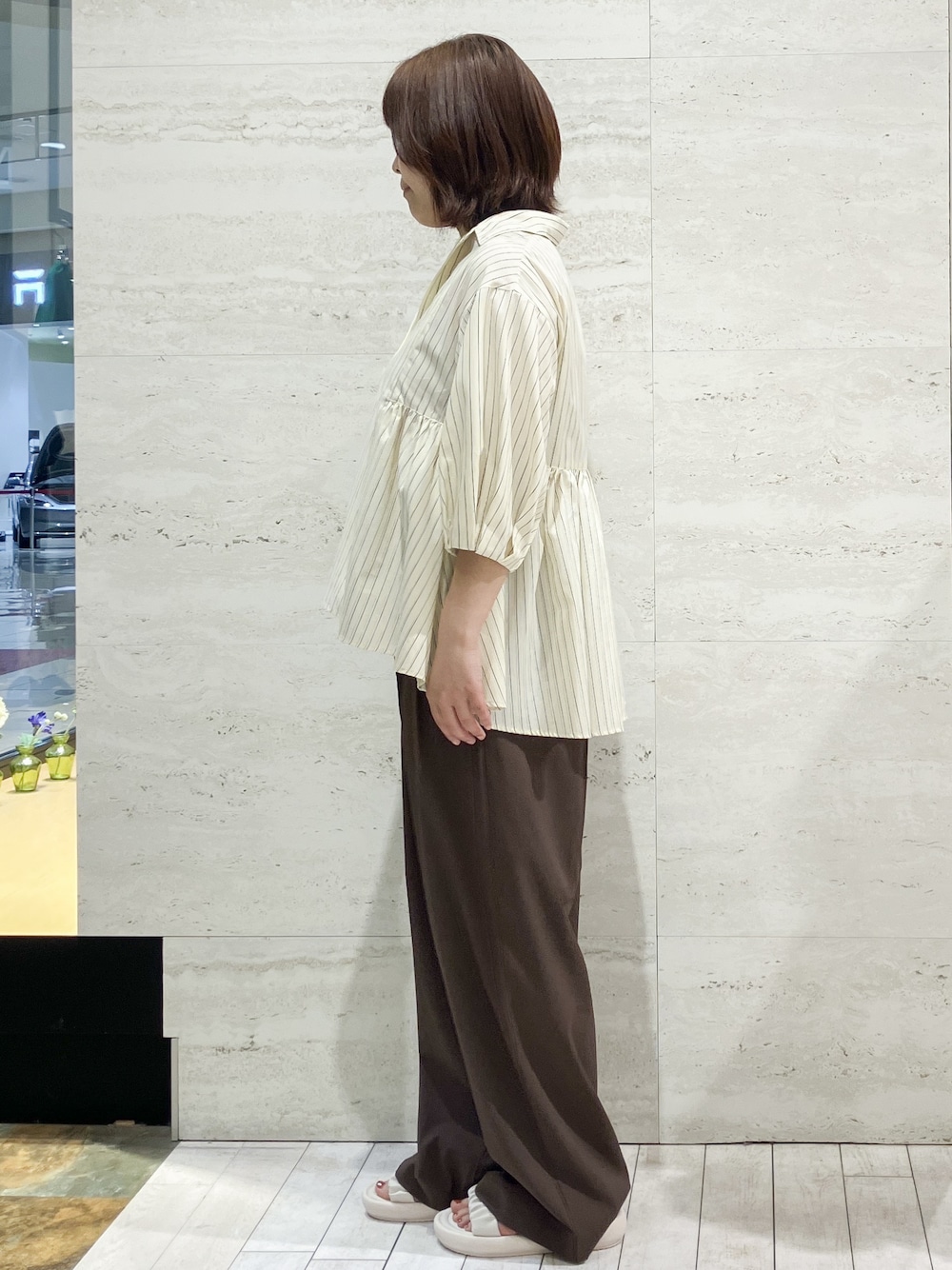 イエロー系のシャツ/ブラウス、ブラウン系のその他パンツ、ホワイト系のサンダルを着用したレディースの夏コーディネートの2枚目の写真