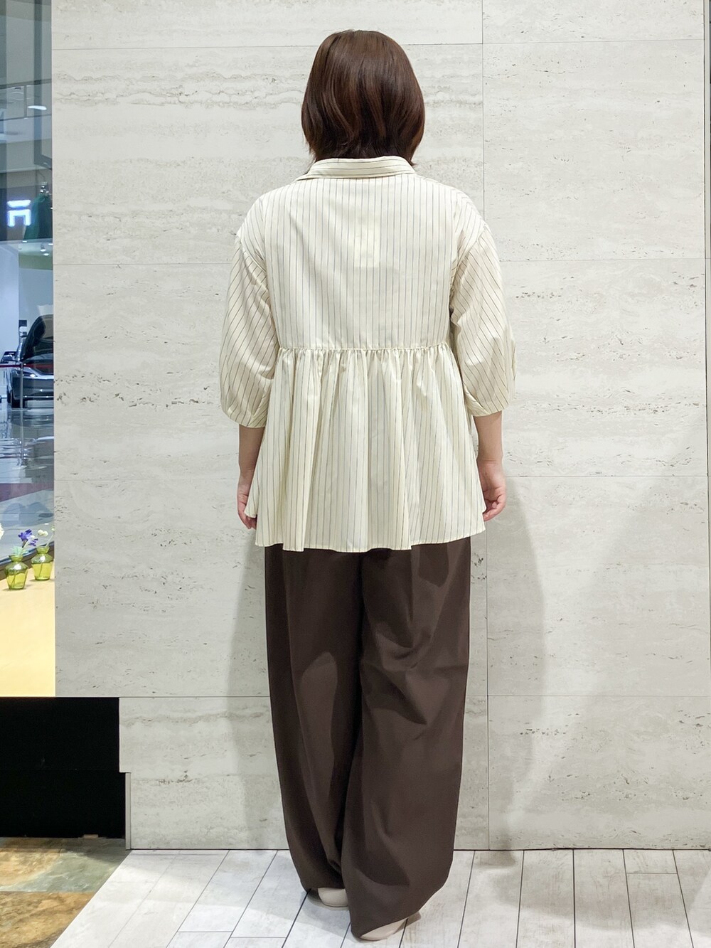 イエロー系のシャツ/ブラウス、ブラウン系のその他パンツ、ホワイト系のサンダルを着用したレディースの夏コーディネートの3枚目の写真