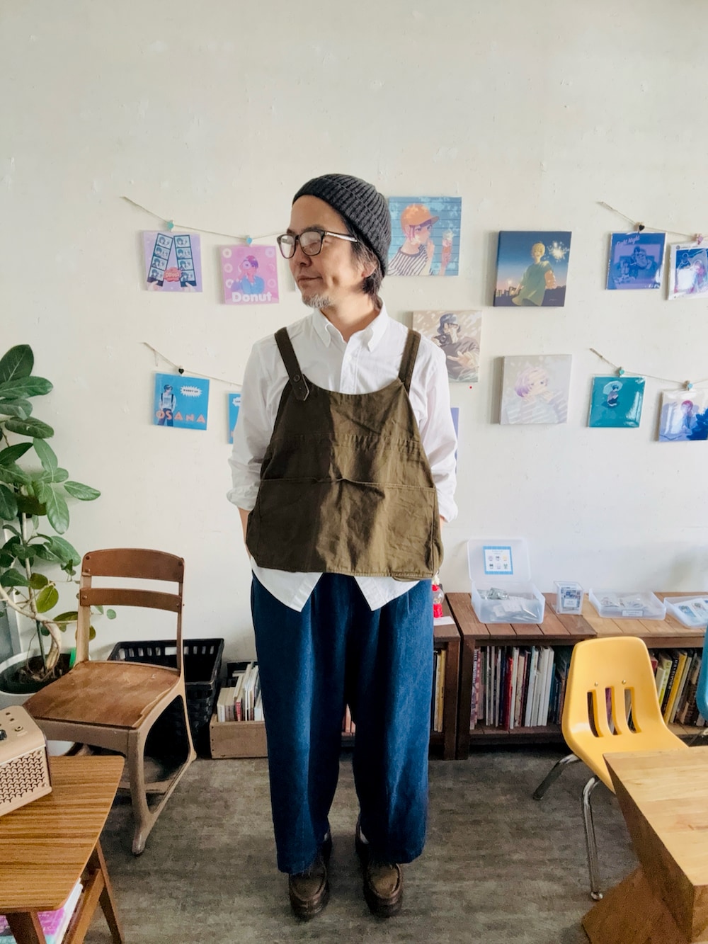 ブラウン系のドレスシューズ、ブルー系のデニムパンツ、グリーン系のベストを着用したメンズの春コーディネートの2枚目の写真