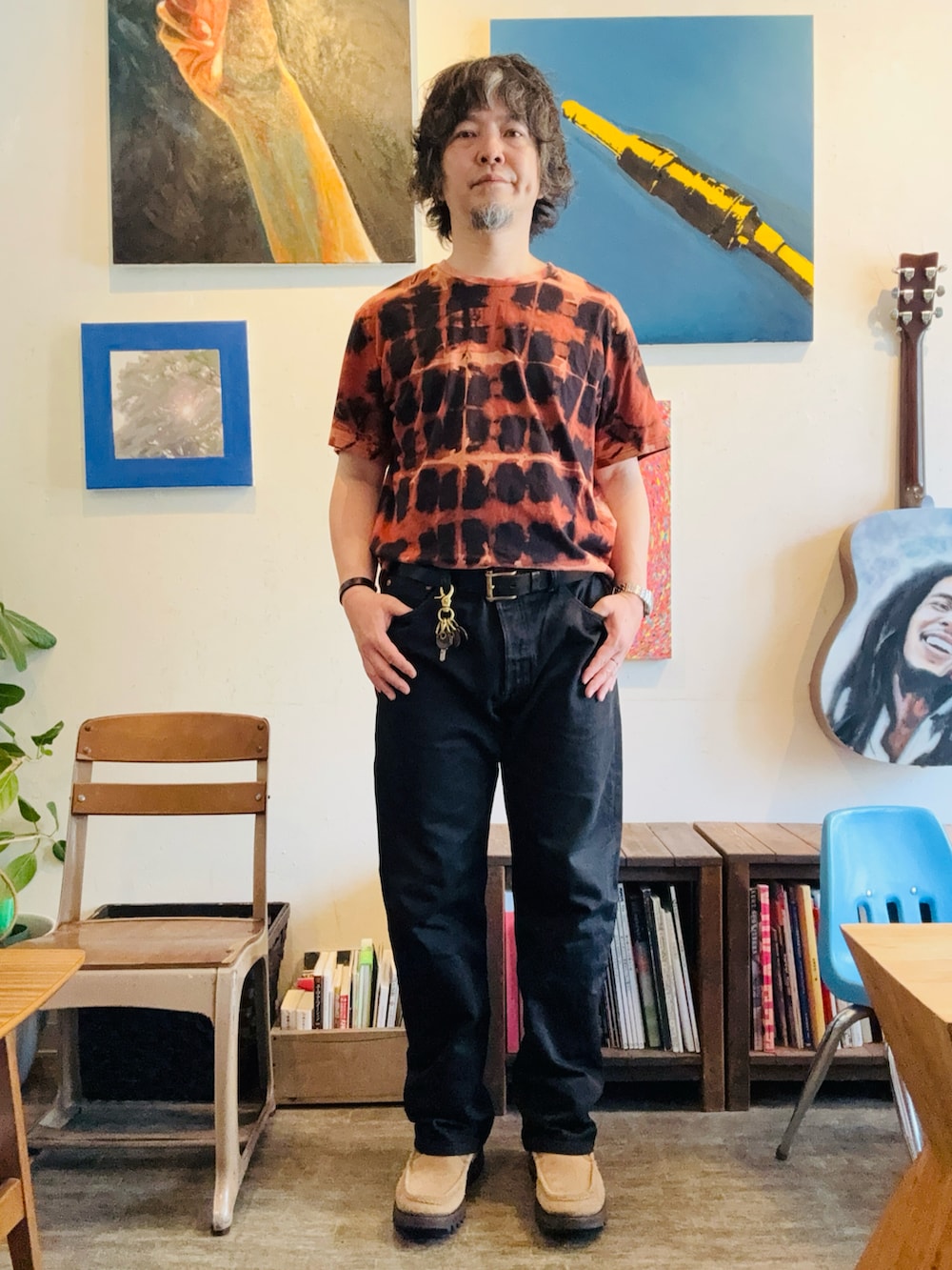 ブラック系のデニムパンツ、ベージュ系のブーツ、その他のTシャツ/カットソーを着用したメンズの春コーディネートの2枚目の写真
