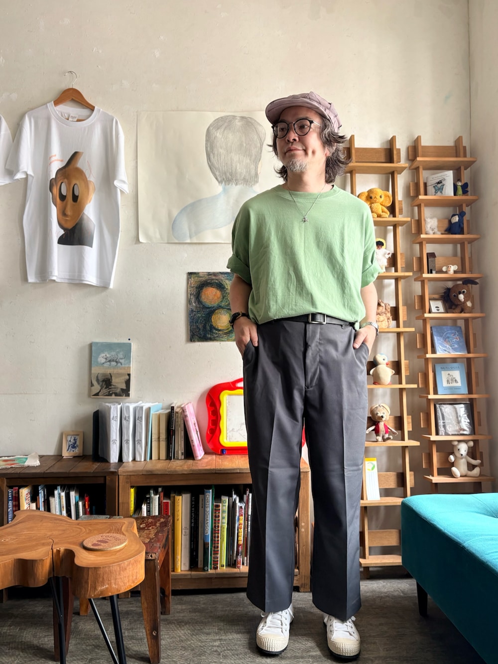 グレー系のスラックス、ホワイト系のスニーカー、グリーン系のTシャツ/カットソーを着用したメンズの夏コーディネートの2枚目の写真