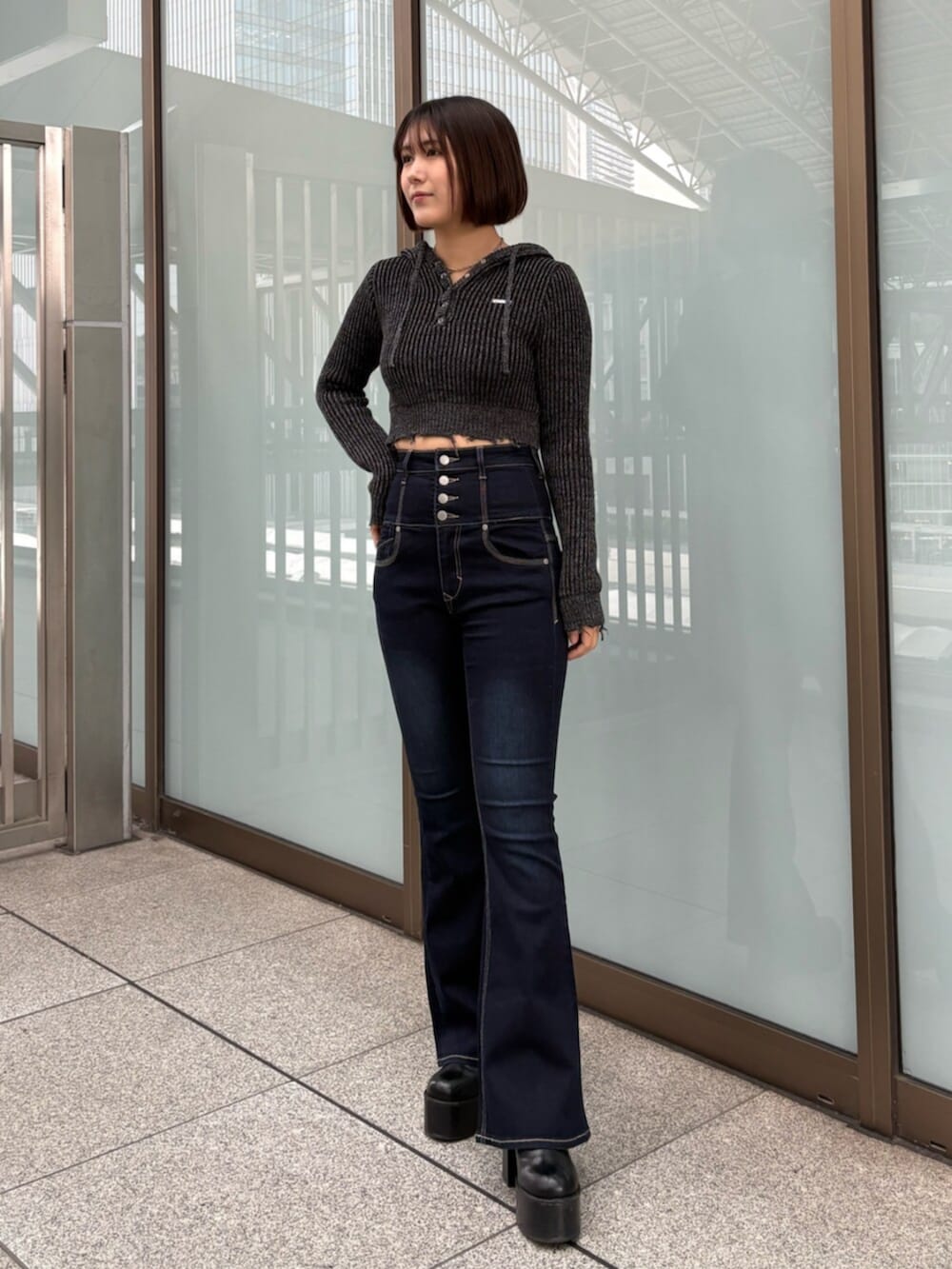 ブラウン系のブルゾン、ブラック系のデニムパンツ、ブラック系のニット/セーターを着用したレディースの冬コーディネートの7枚目の写真