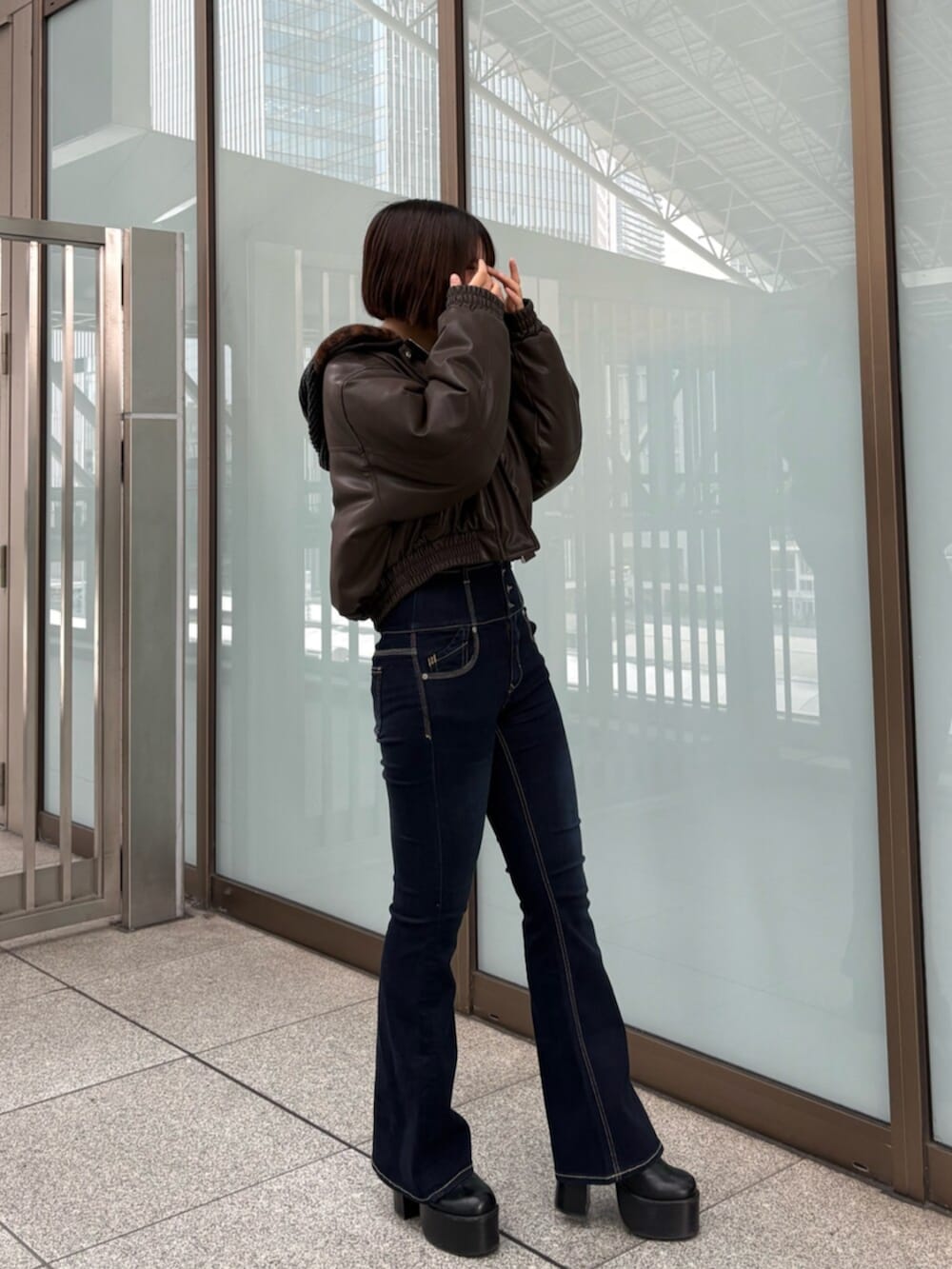 ブラウン系のブルゾン、ブラック系のデニムパンツ、ブラック系のニット/セーターを着用したレディースの冬コーディネートの3枚目の写真