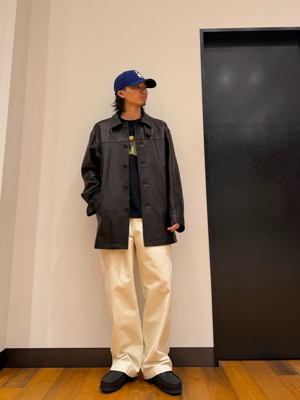 ブラック系のTシャツ/カットソー、ブラック系のその他アウター、ホワイト系のその他パンツを着用したメンズの秋コーディネートの5枚目の写真