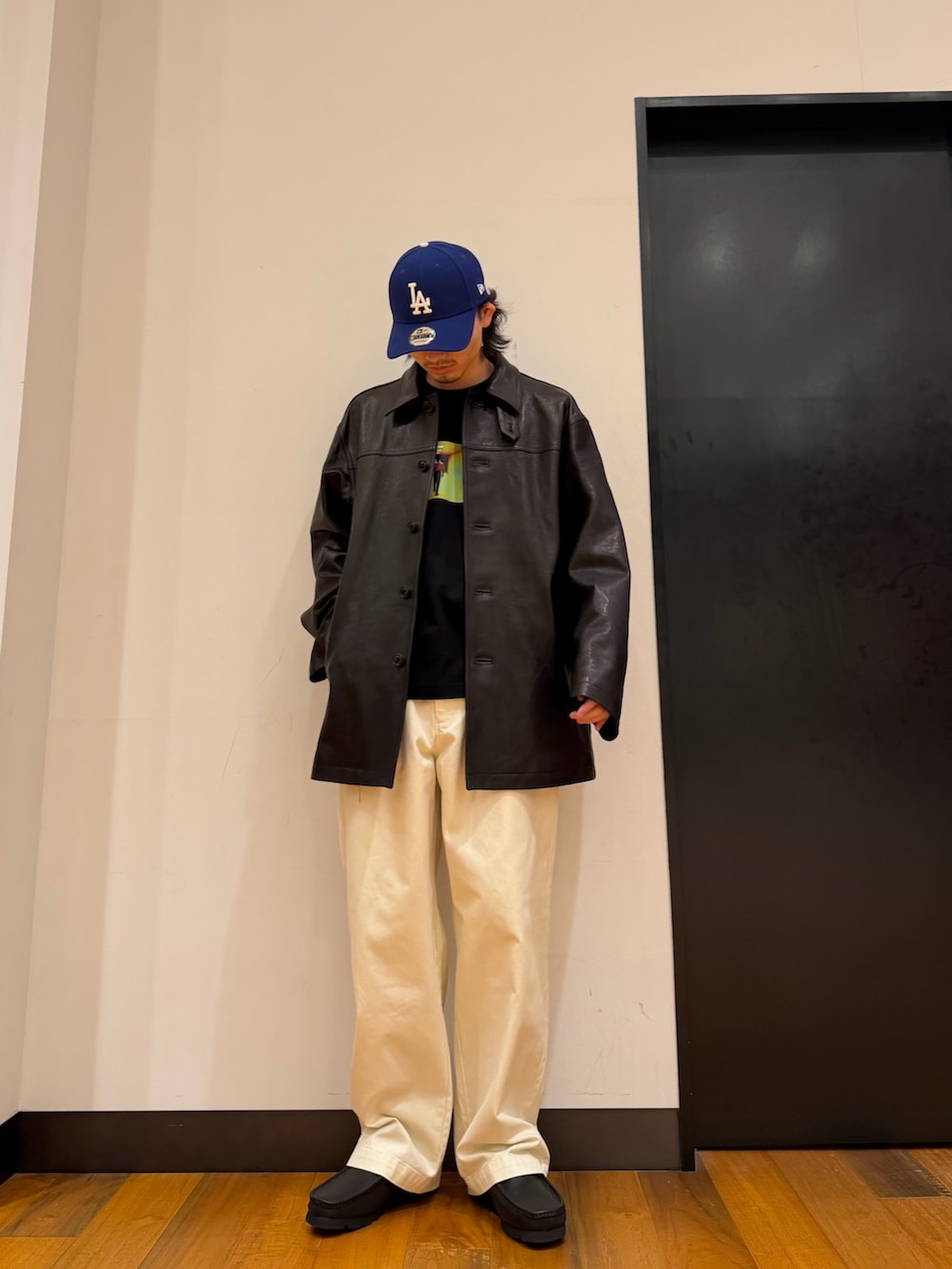 ブラック系のTシャツ/カットソー、ブラック系のその他アウター、ホワイト系のその他パンツを着用したメンズの秋コーディネートの2枚目の写真