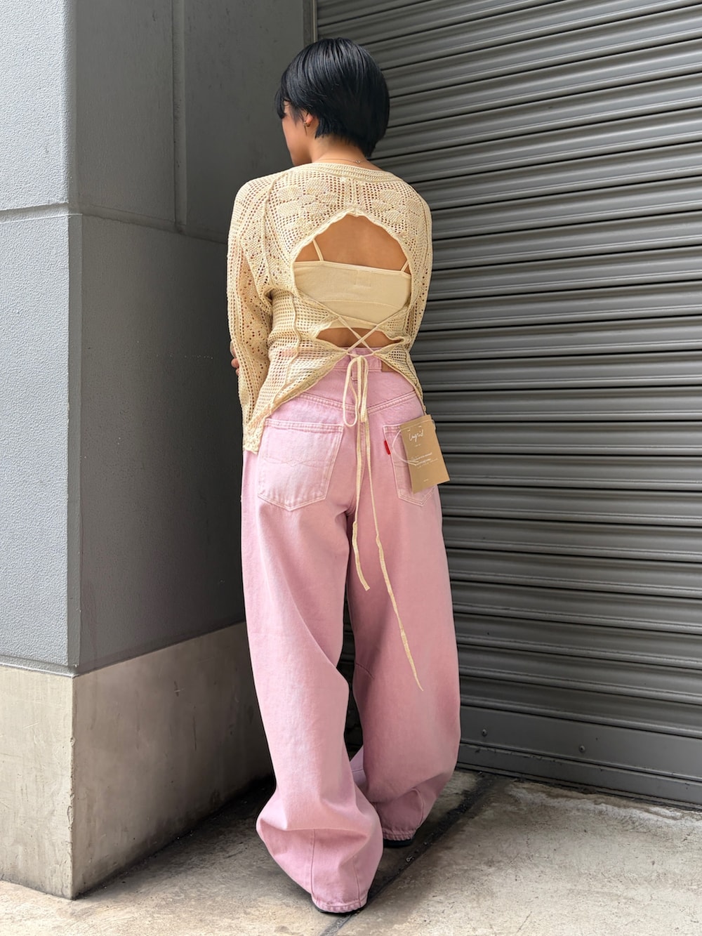 ピンク系のデニムパンツ、ホワイト系のキャミソール、ホワイト系のニット/セーターを着用したレディースの春コーディネートの3枚目の写真