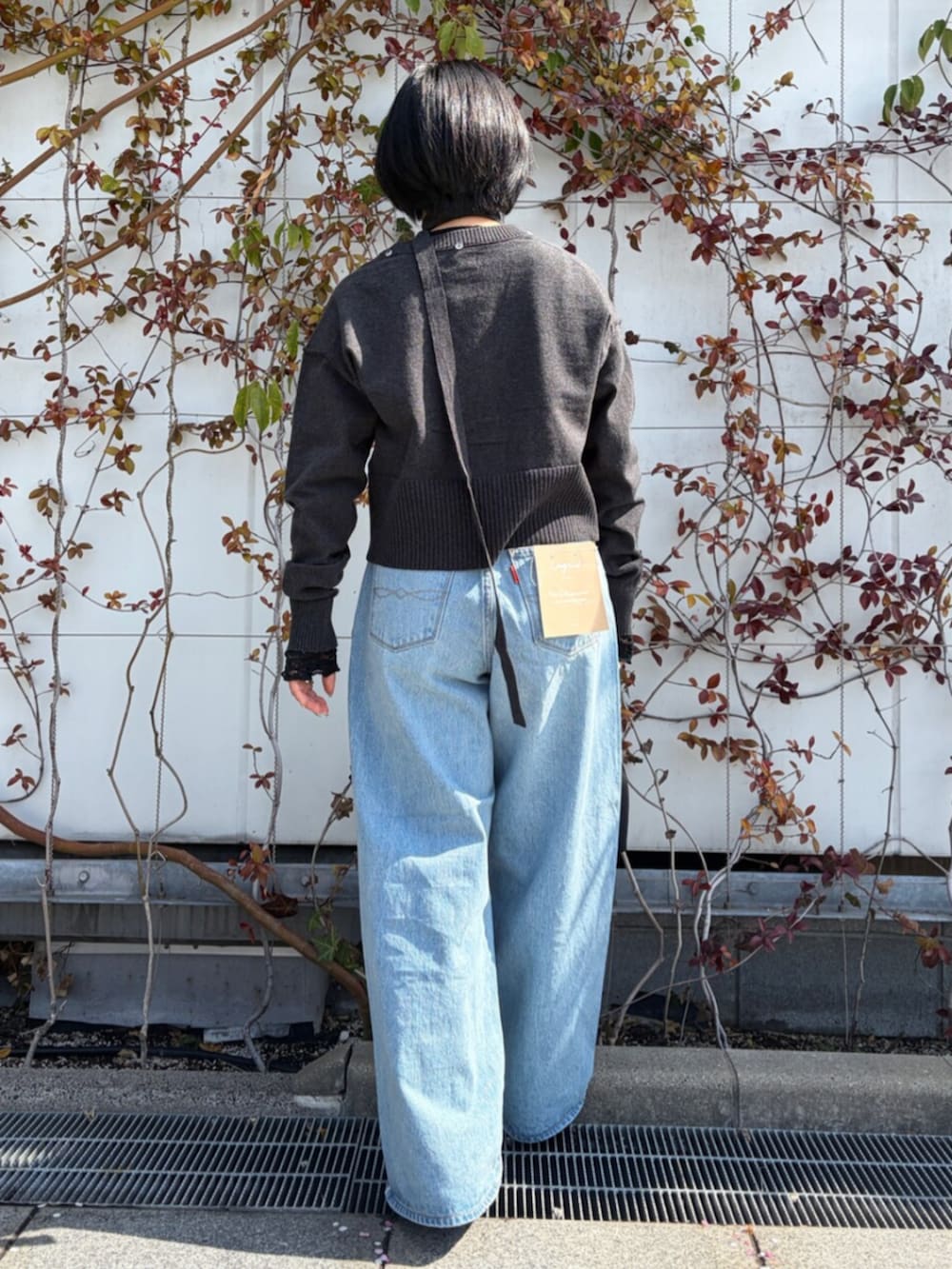 ブルー系のデニムパンツ、グレー系のカーディガン/ボレロを着用したレディースの春コーディネートの3枚目の写真