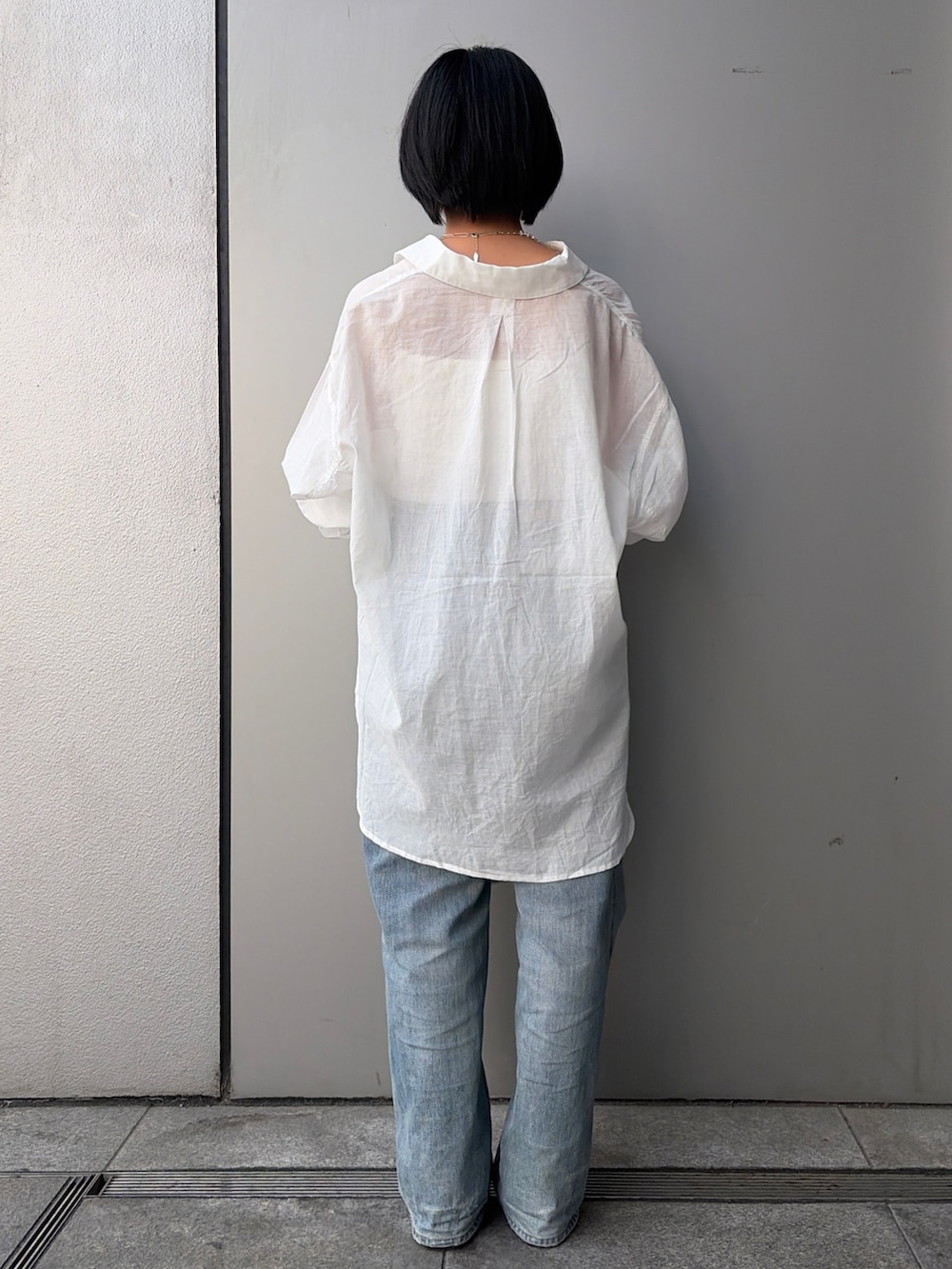 ブルー系のデニムパンツ、ホワイト系のシャツ/ブラウス、ブルー系のネックレスを着用したレディースの春コーディネートの3枚目の写真