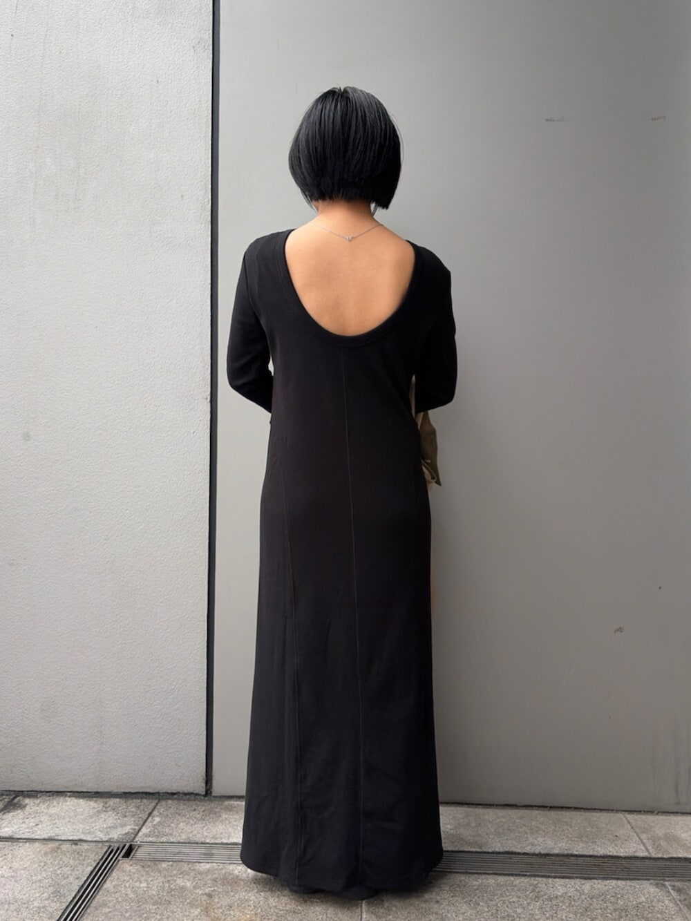 ブラック系のワンピース、グリーン系のトレンチコートを着用したレディースの春コーディネートの3枚目の写真