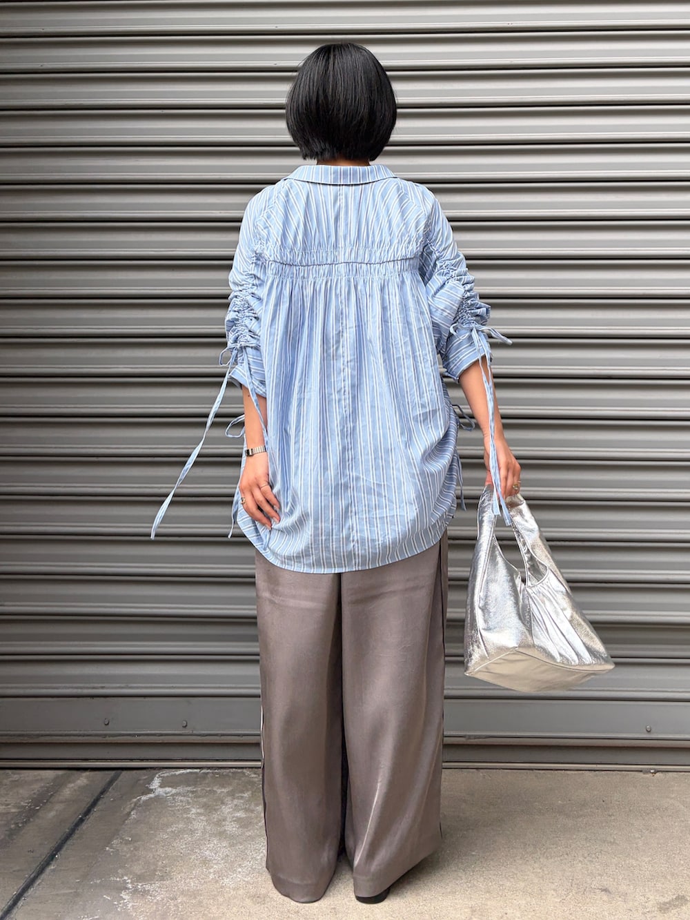 ブルー系のシャツ/ブラウス、グレー系のその他パンツ、ブラック系のサンダルを着用したレディースの春コーディネートの3枚目の写真