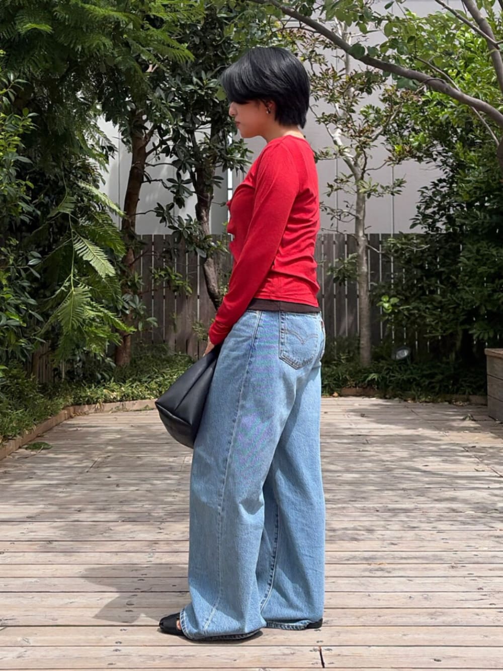 レッド系のカーディガン/ボレロ、ブルー系のデニムパンツ、ブラック系のTシャツ/カットソーを着用したレディースの夏コーディネートの2枚目の写真
