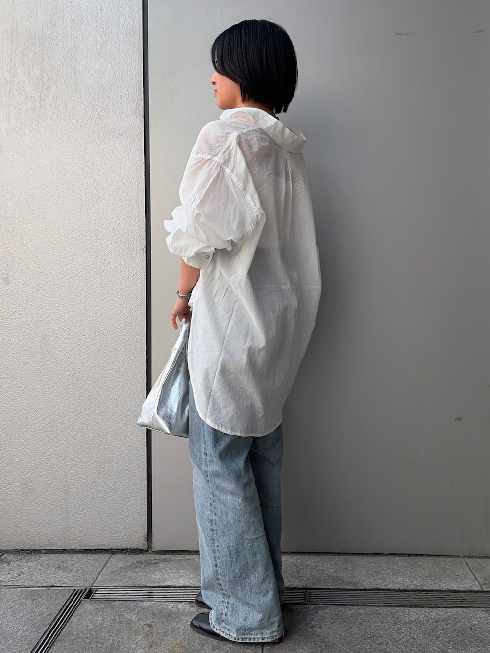 ブルー系のデニムパンツ、ホワイト系のシャツ/ブラウス、ブルー系のネックレスを着用したレディースの春コーディネートの2枚目の写真