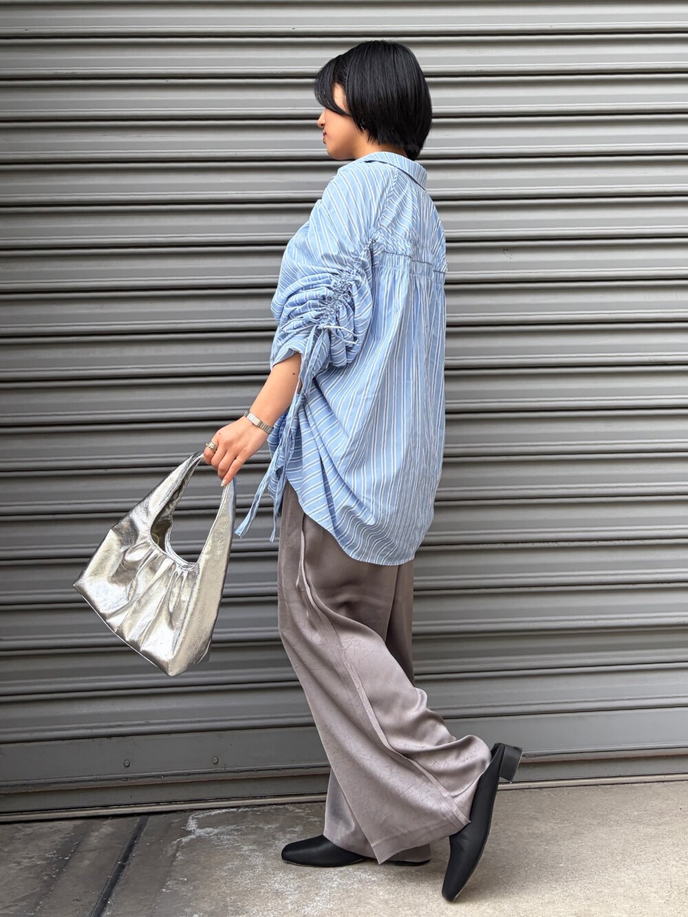 ブルー系のシャツ/ブラウス、グレー系のその他パンツ、ブラック系のサンダルを着用したレディースの春コーディネートの2枚目の写真