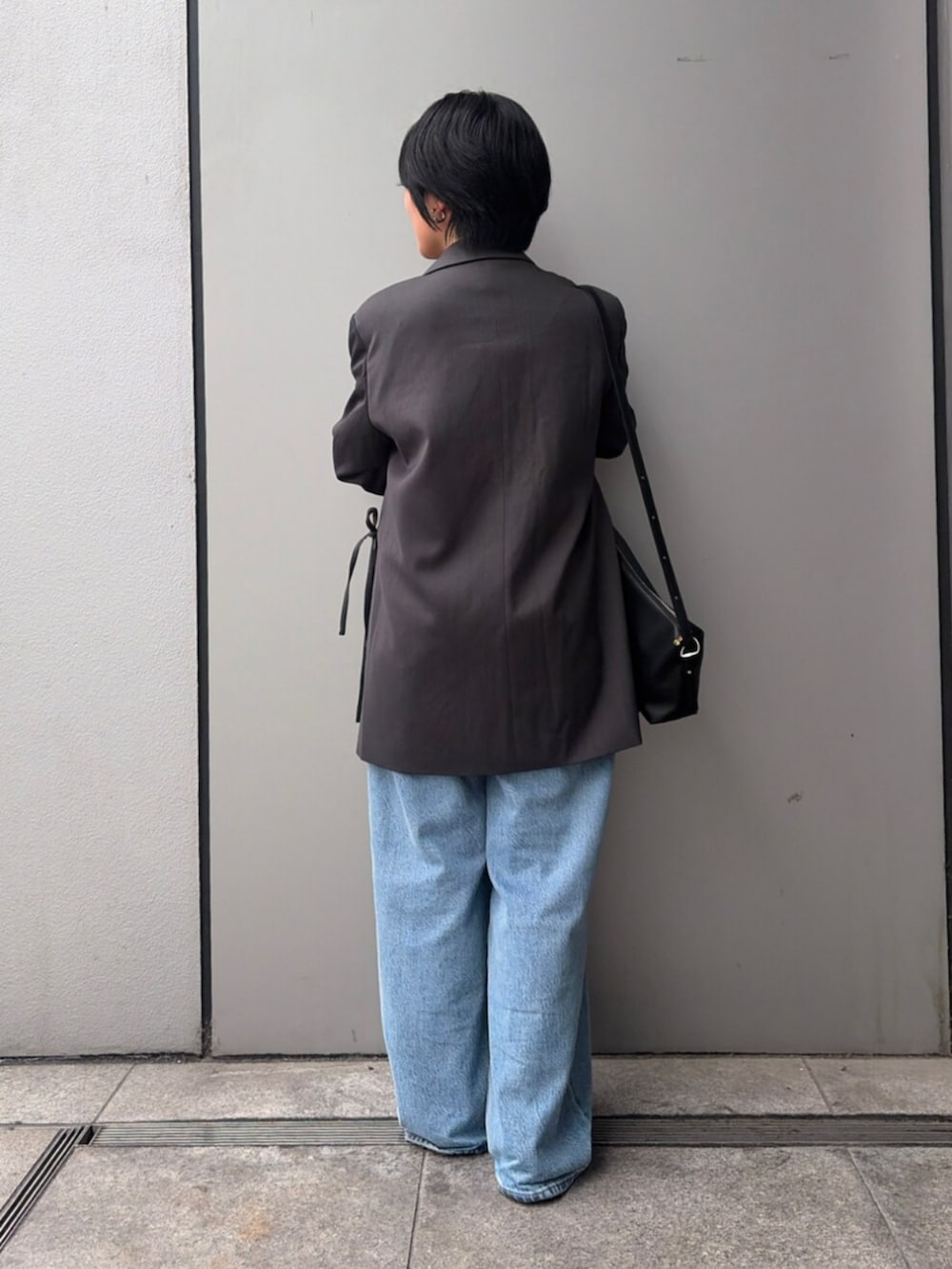 ブルー系のデニムパンツ、グレー系のテーラードジャケット、ホワイト系のTシャツ/カットソーを着用したレディースの夏コーディネートの3枚目の写真