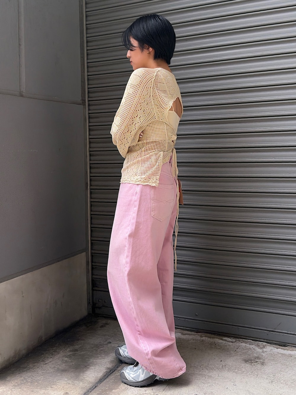 ピンク系のデニムパンツ、ホワイト系のキャミソール、ホワイト系のニット/セーターを着用したレディースの春コーディネートの2枚目の写真