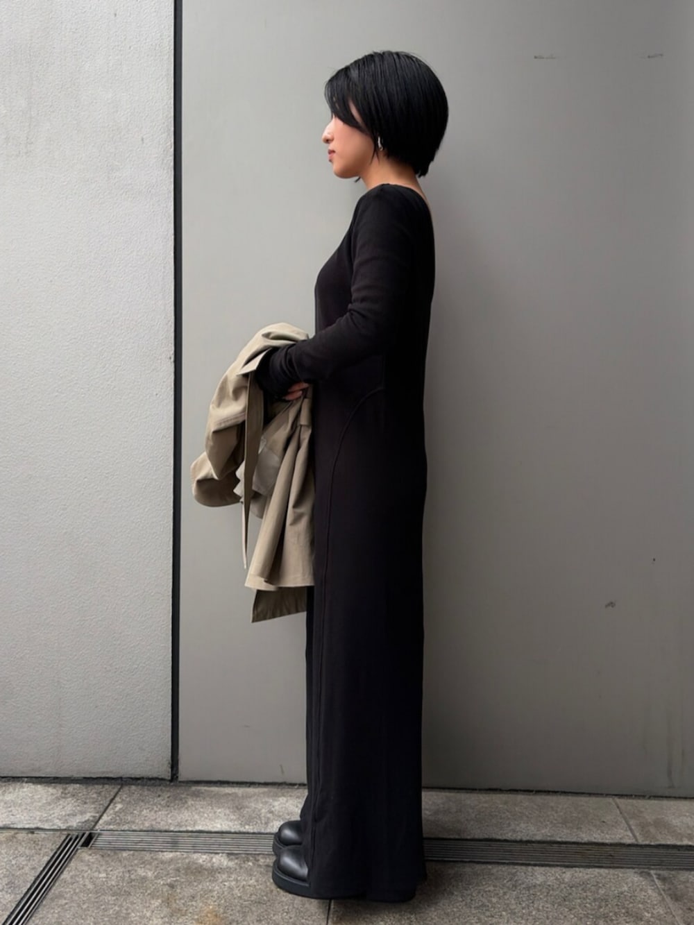 ブラック系のワンピース、グリーン系のトレンチコートを着用したレディースの春コーディネートの2枚目の写真