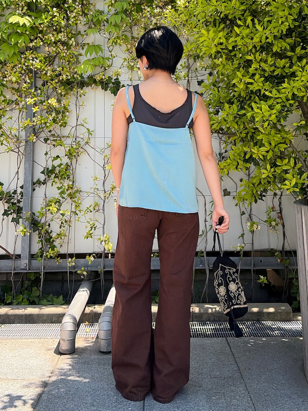 ブラウン系のデニムパンツ、ブルー系のキャミソール、グレー系のタンクトップを着用したレディースの春コーディネートの3枚目の写真