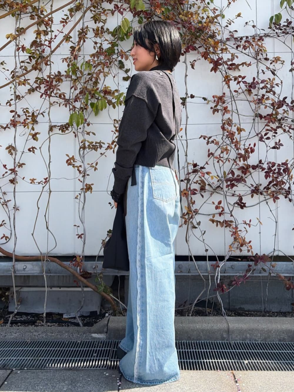 ブルー系のデニムパンツ、グレー系のカーディガン/ボレロを着用したレディースの春コーディネートの2枚目の写真