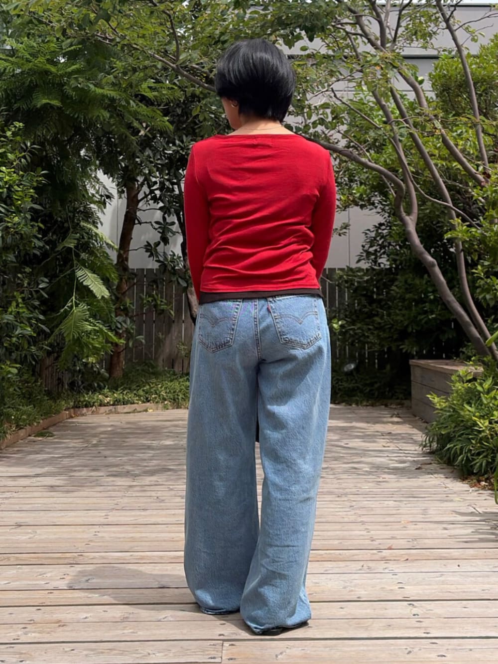 レッド系のカーディガン/ボレロ、ブルー系のデニムパンツ、ブラック系のTシャツ/カットソーを着用したレディースの夏コーディネートの3枚目の写真
