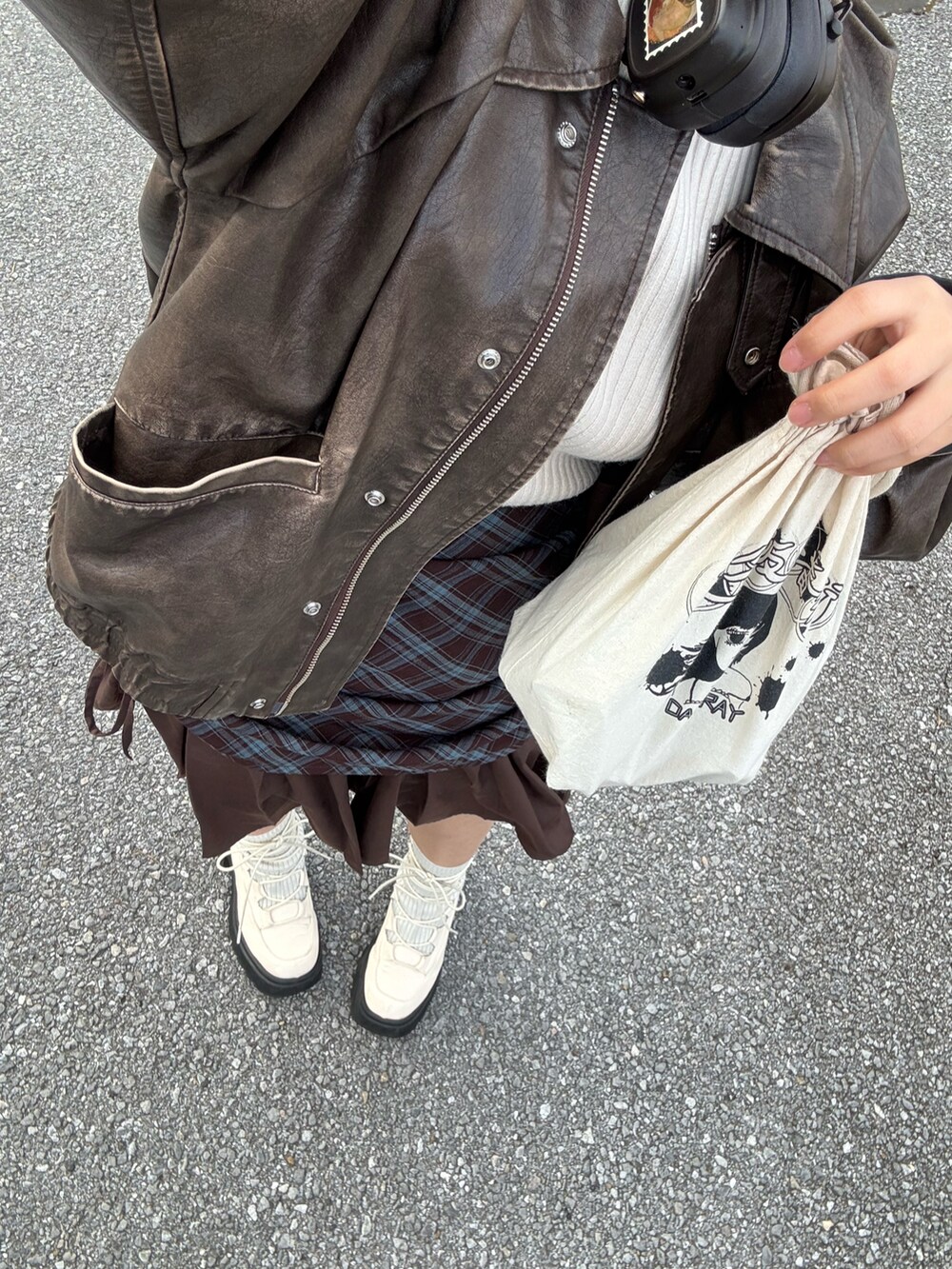 ホワイト系のブーツ、ベージュ系のハンドバッグ、ブラウン系のスカートを着用したレディースの冬コーディネートの2枚目の写真