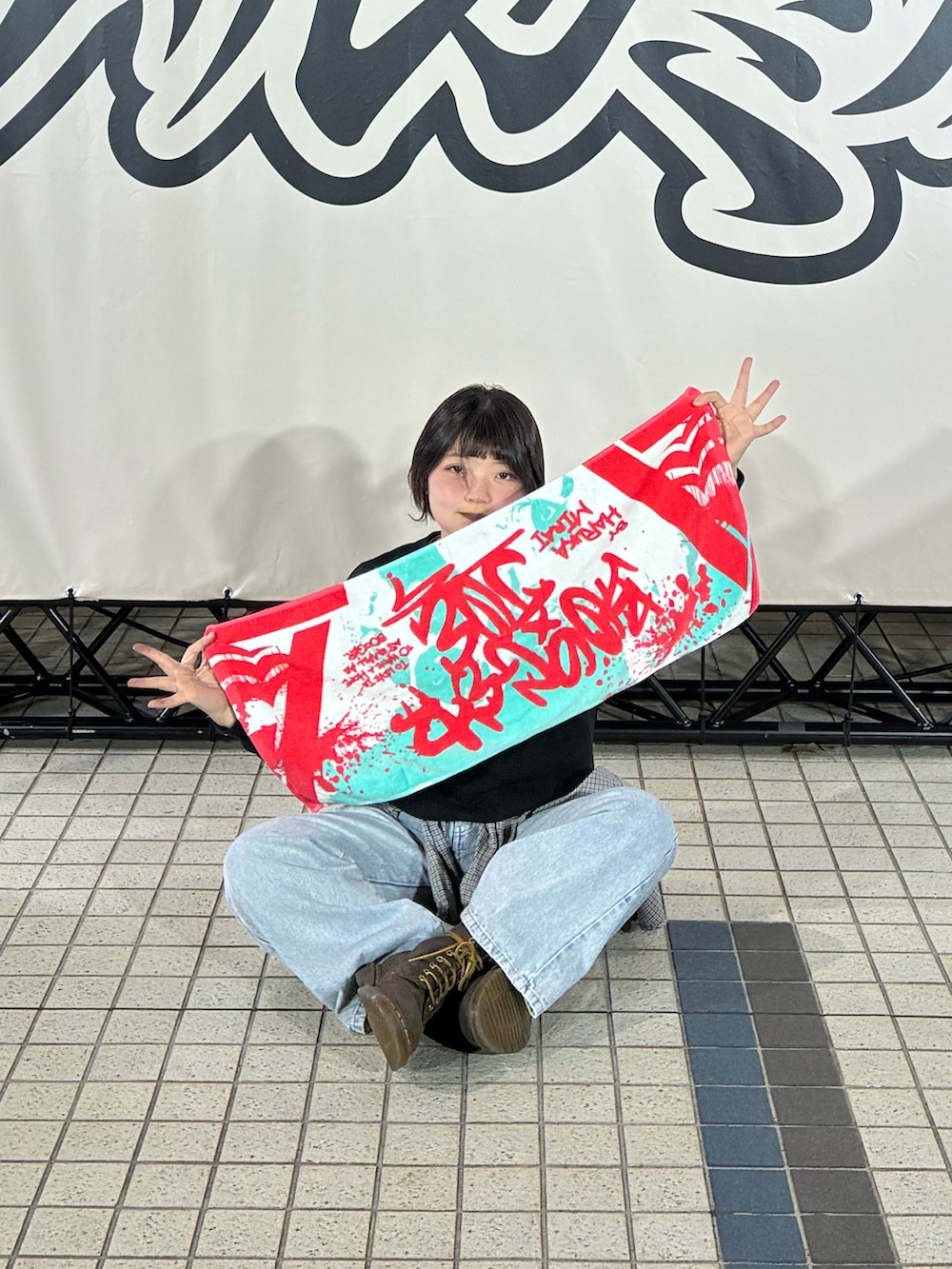 ブラック系のスウェット、ブラウン系のブーツ、ブルー系のデニムパンツを着用したレディースの春コーディネートの3枚目の写真